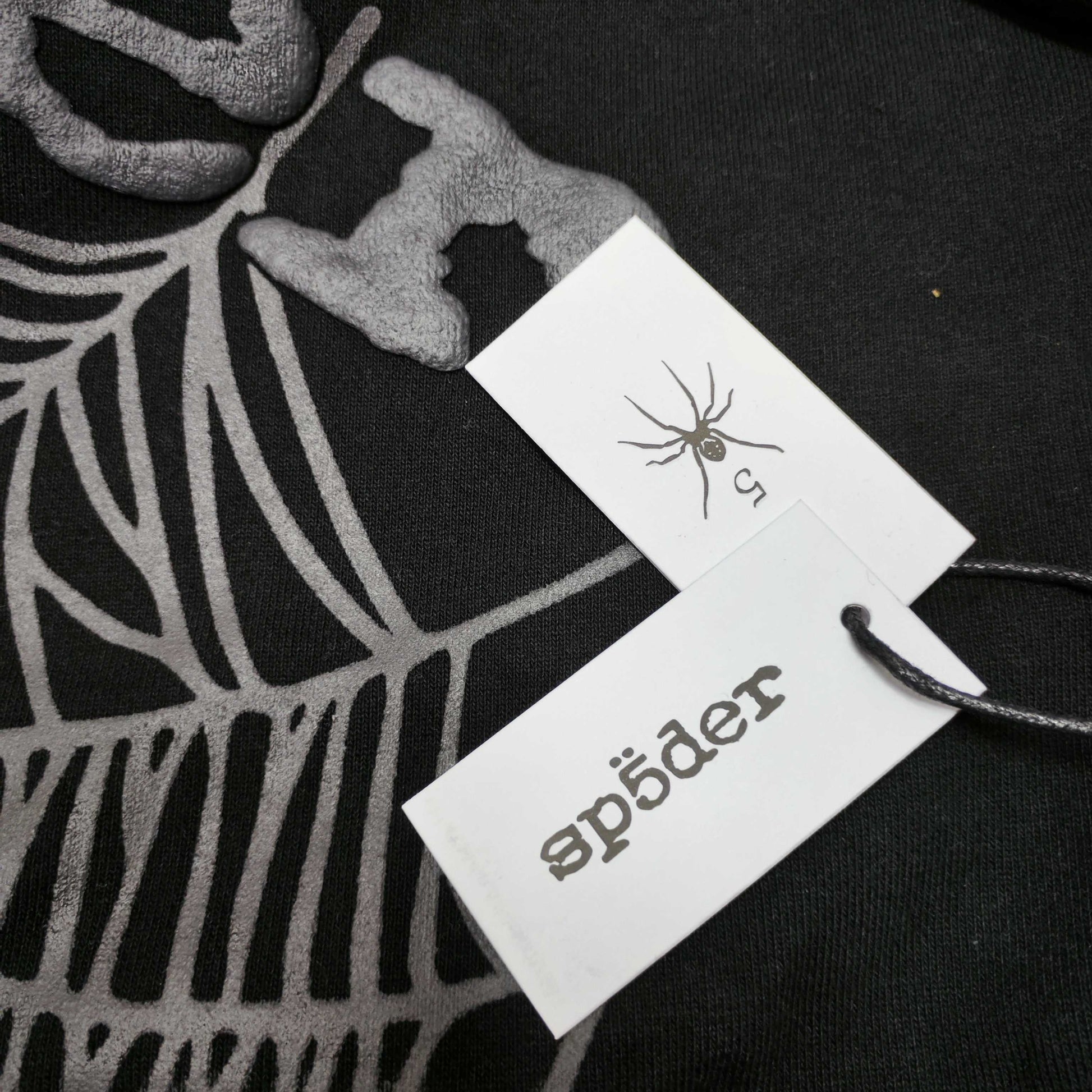 Sp5der OG Web Hoodie Black neck label and size tag detail
Sp5der OG Web Hoodie Black care label and washing instruction detail