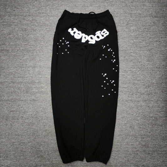 SP5DER OG Web black sweatpants front view with white logo and scattered star graphics