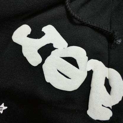 Raised white puff-print texture on SP5DER OG Web black sweatpants