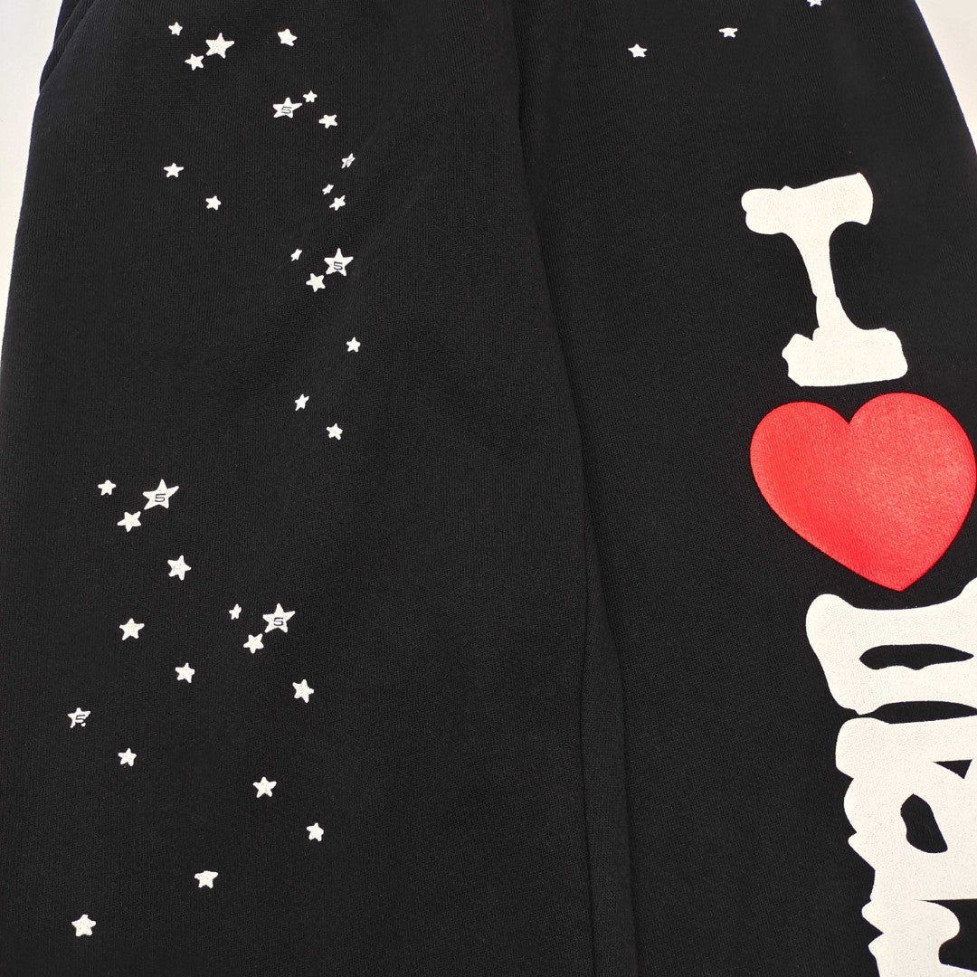 Red heart graphic detail on SP5DER Souvenir black sweatpants
Scattered white star graphics on SP5DER Souvenir black sweatpants