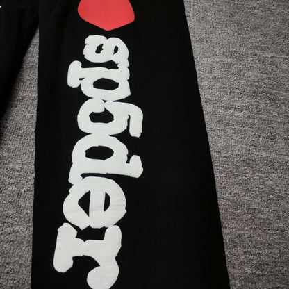 White I Heart SP5DER leg graphic with red heart on black Souvenir sweatpants
Raised white puff-print texture on SP5DER Souvenir black sweatpants