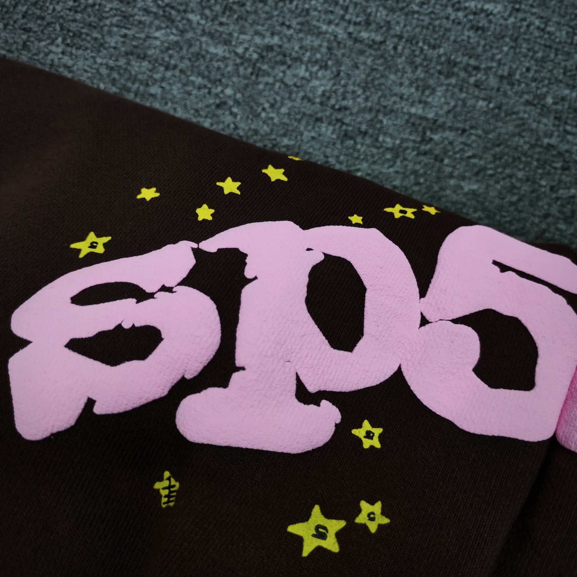 Close-up of pink SP5DER puff-print logo on Classic brown sweatpants
Close-up of defined puff-print edges on SP5DER Classic sweatpants