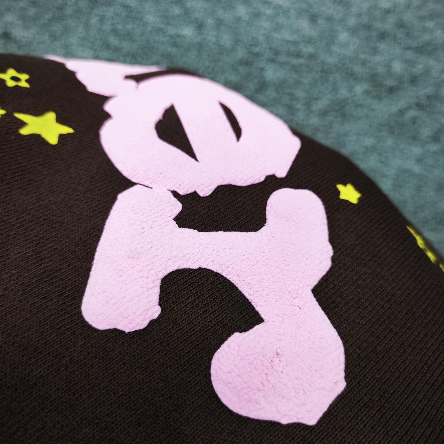 Close-up of pink SP5DER puff-print logo on Classic brown sweatpants
Raised pink puff-print texture on SP5DER Classic brown sweatpants
Close-up of defined puff-print edges on SP5DER Classic sweatpants