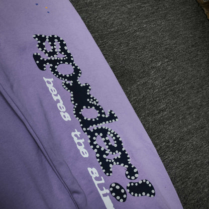 Navy SP5DER leg graphic and multicolor stars on Acai purple sweatpants