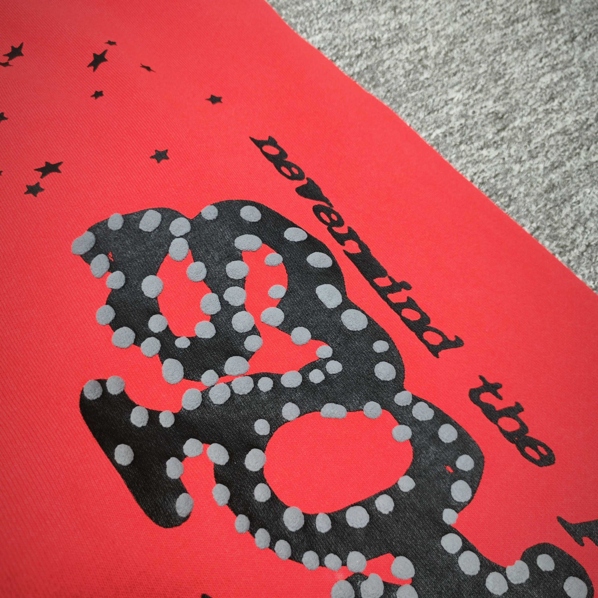 Close-up of black SP5DER puff-print graphic on red P*NK V2 sweatpants
Raised black puff-print texture on SP5DER P*NK V2 red sweatpants
Close-up of defined puff-print edges on SP5DER P*NK V2 sweatpants