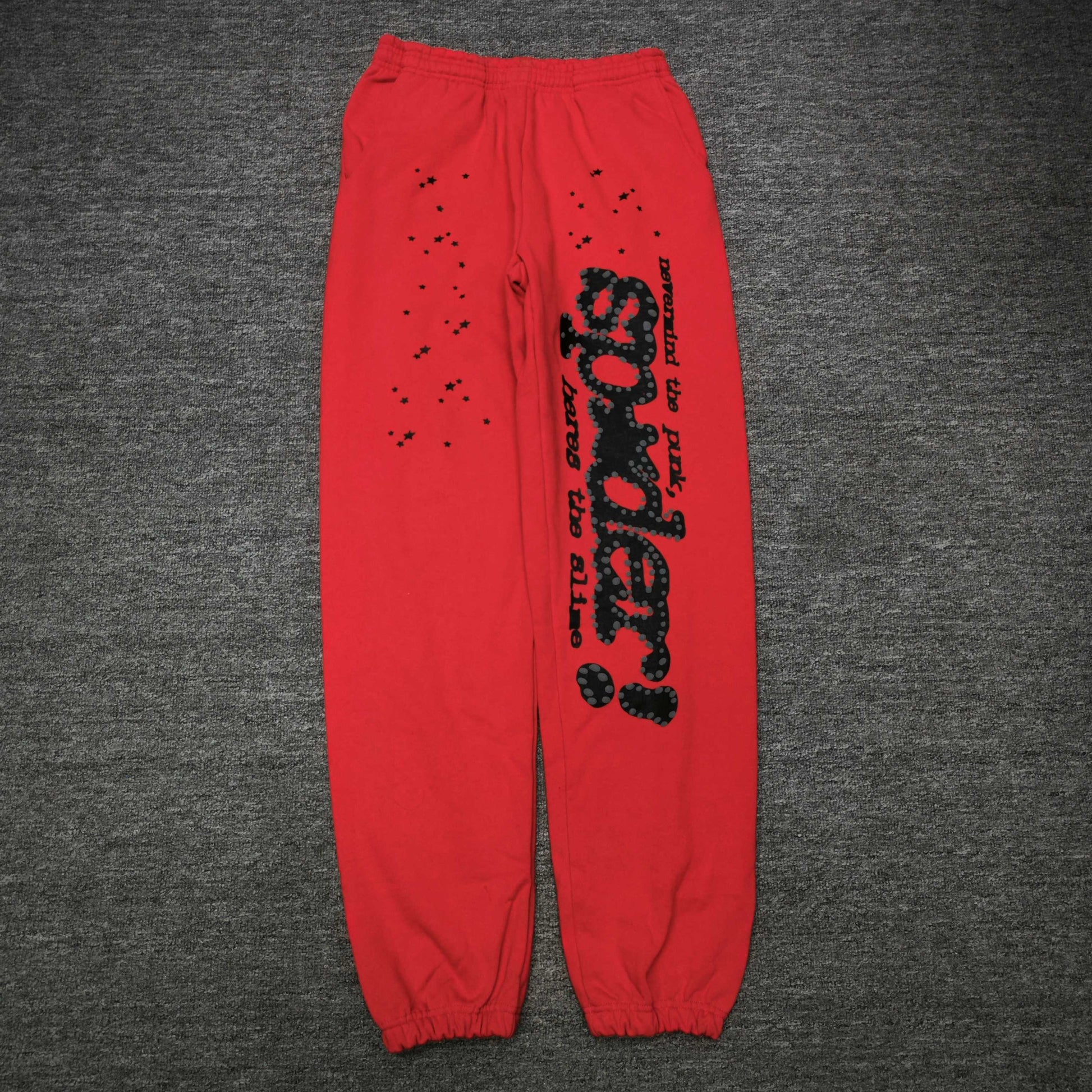 SP5DER P*NK V2 red sweatpants front view with black leg graphic and scattered stars