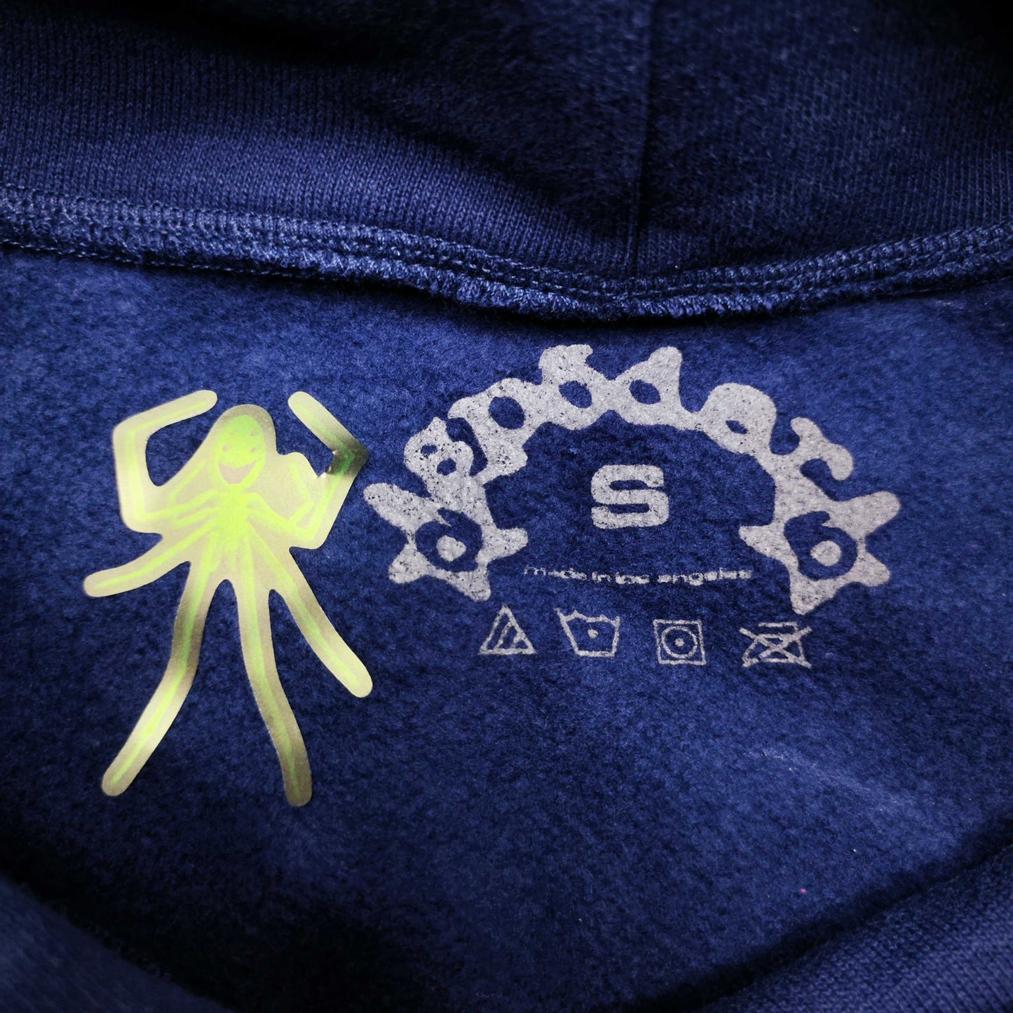Sp5der OG Web Hoodie Navy neck label and size tag detail
Sp5der OG Web Hoodie Navy care label and washing instruction detail