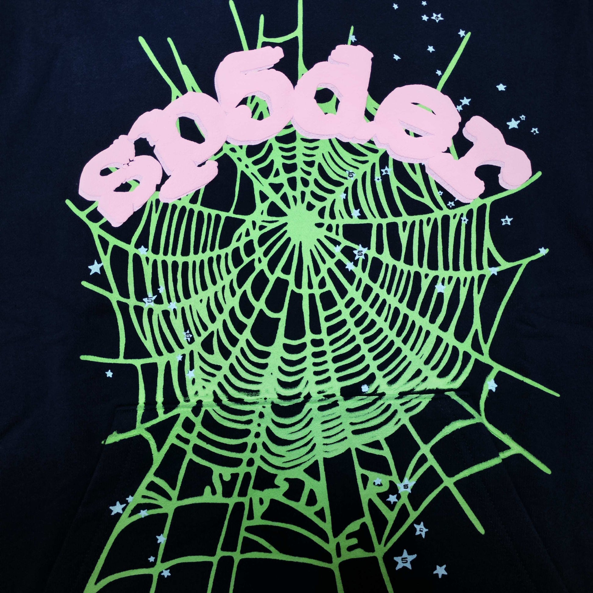 Full front artwork on Sp5der OG Web Hoodie Navy with pink puff logo, green web and stars
Close-up of raised pink SP5DER puff-print lettering on the Navy OG Web Hoodie
Side angle showing the three-dimensional pink puff-print texture on Sp5der OG Web Hoodie Navy
Close-up of mint-green spider-web artwork on Sp5der OG Web Hoodie Navy