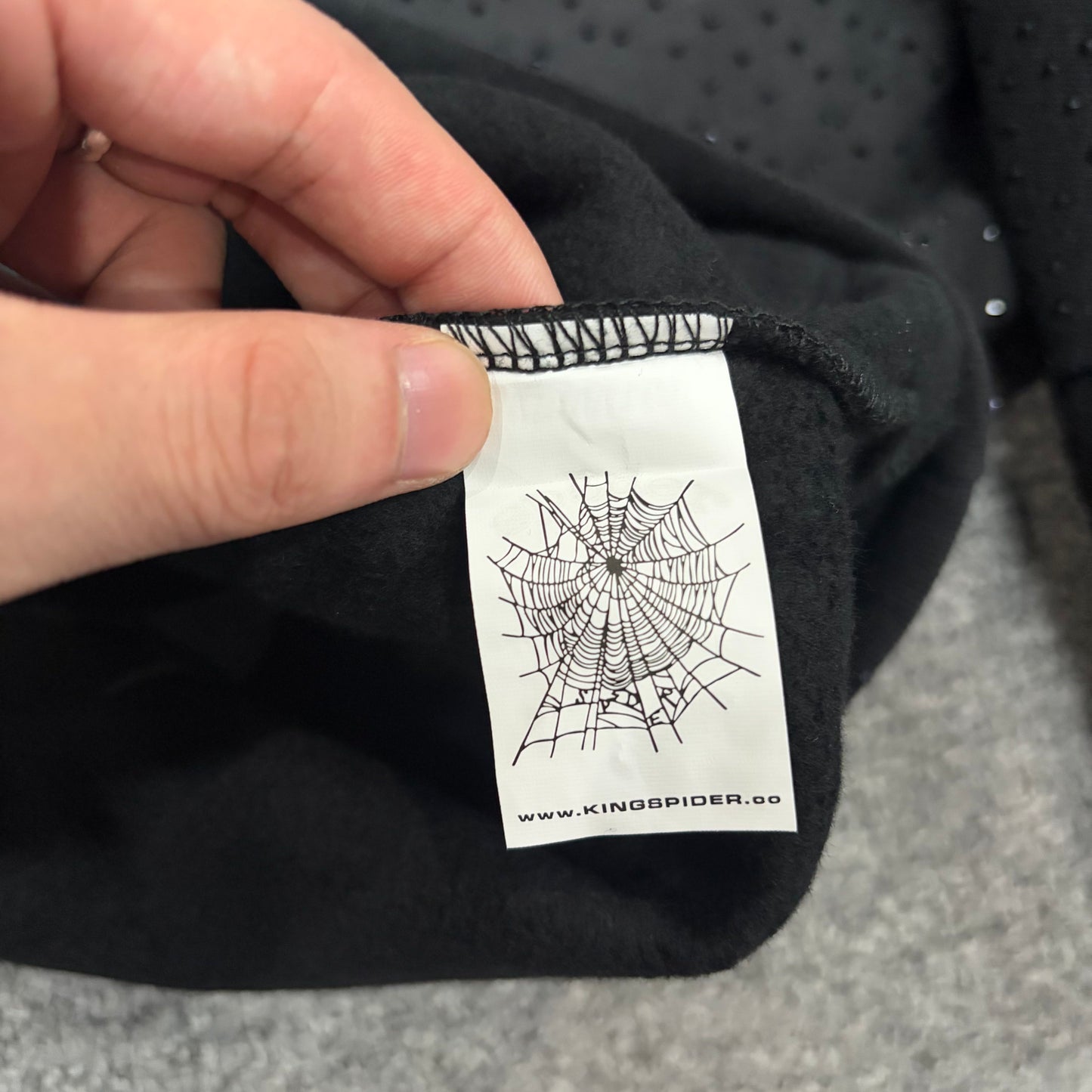 Sp5der VVS Hoodie neck label and size tag detail
Sp5der VVS Hoodie care label and washing instruction detail