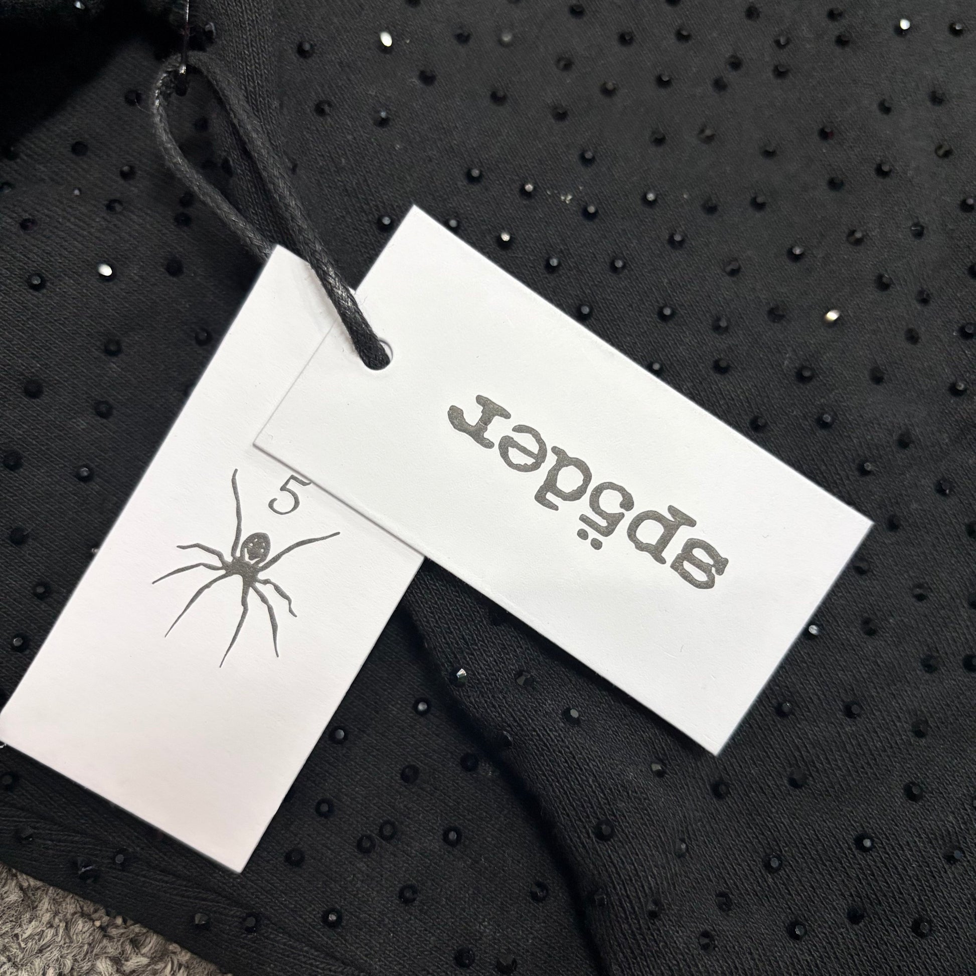 Sp5der VVS Hoodie neck label and size tag detail
Sp5der VVS Hoodie care label and washing instruction detail