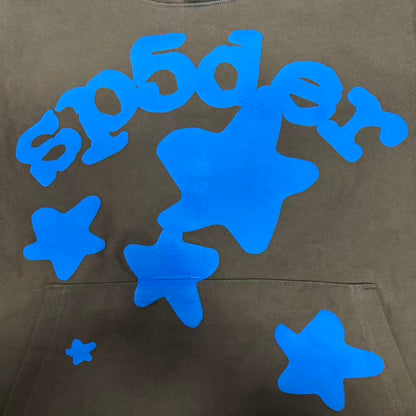 Full blue puff-print artwork on Sp5der Beluga Hoodie Brown with logo, stars and number graphics
Close-up of raised blue SP5DER lettering and clean puff-print edges on the brown Beluga Hoodie
Side angle showing the three-dimensional blue puff-print texture on Sp5der Beluga Hoodie Brown
Oversized blue star graphics across the front of Sp5der Beluga Hoodie Brown