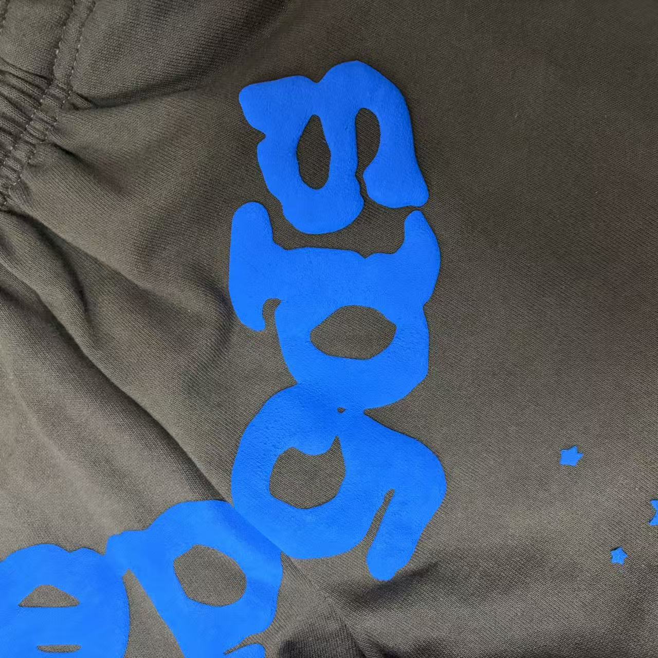 Raised blue puff-print texture on SP5DER Beluga V2 brown sweatpants
Close-up of clean puff-print edges on SP5DER Beluga V2 sweatpants