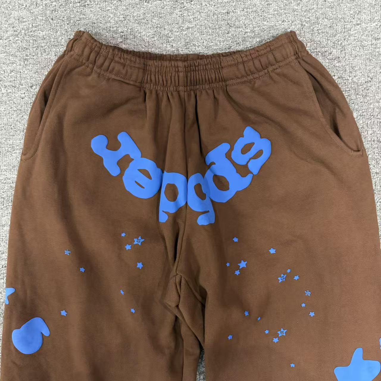 Blue SP5DER logo oversized 5 and star graphics on Beluga V2 brown sweatpants