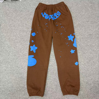 SP5DER Beluga V2 brown sweatpants front view with blue logo and oversized star graphics