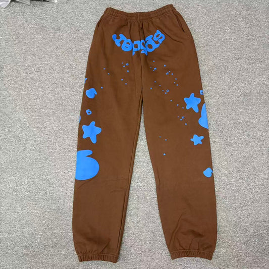 SP5DER Beluga V2 brown sweatpants front view with blue logo and oversized star graphics