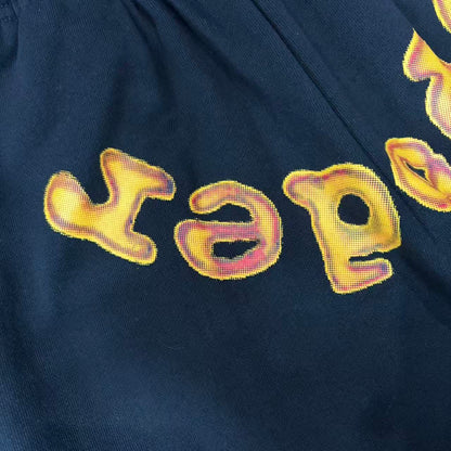 Close-up of orange chenille-style SP5DER lettering on Issue 404 sweatpants
Frayed edge detail on orange SP5DER chenille lettering
Close-up of stitched edges on SP5DER Issue 404 chenille logo
Faded graphic print detail on SP5DER Issue 404 black sweatpants