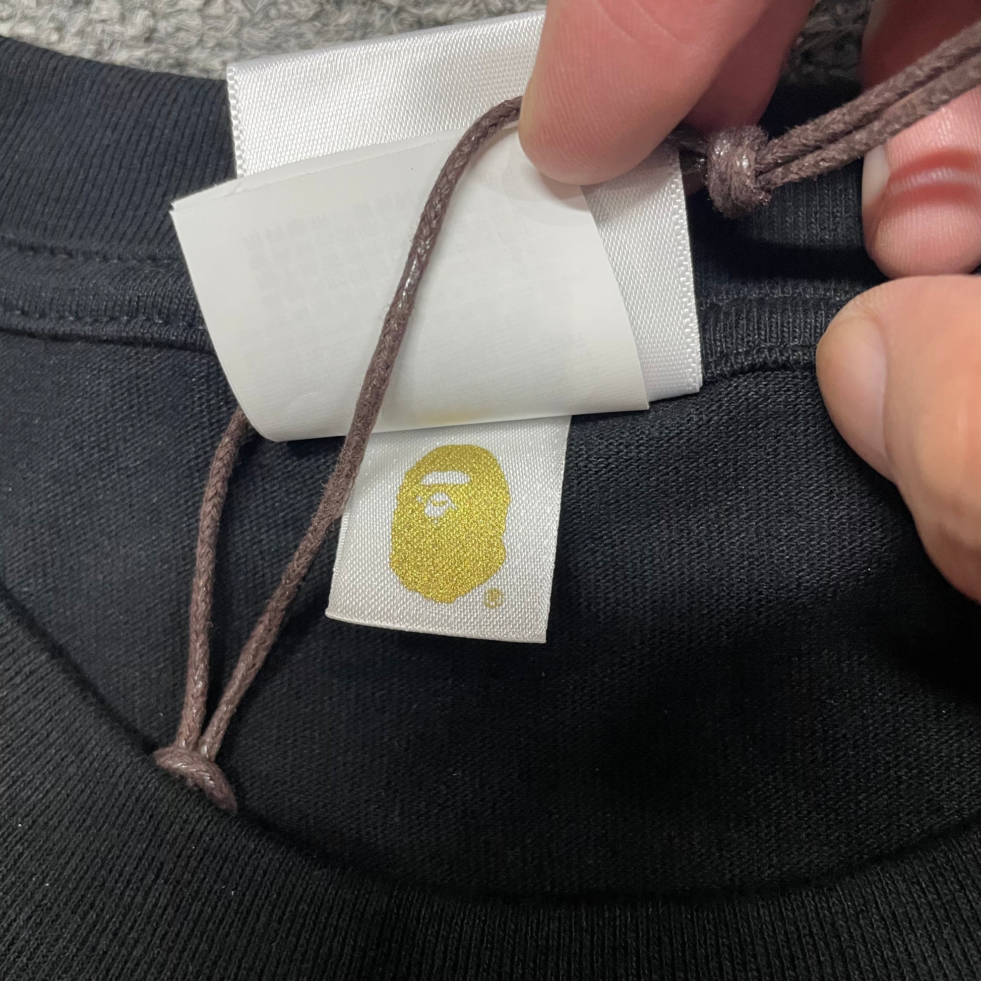 Gold label detail of black BAPE Color Camo Big Ape Head T-shirt