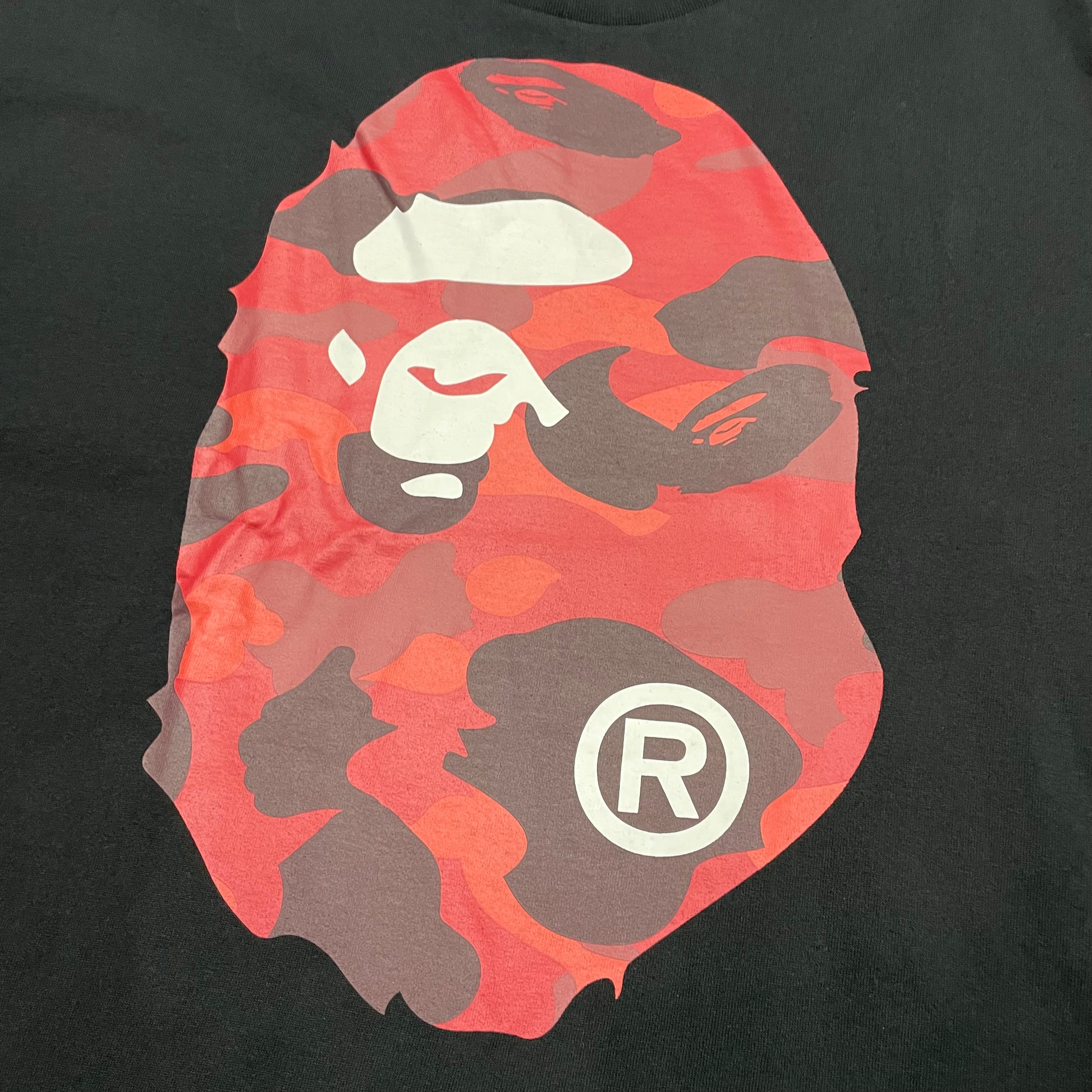 Close-up of red camo Ape Head front graphic on black BAPE T-shirt
