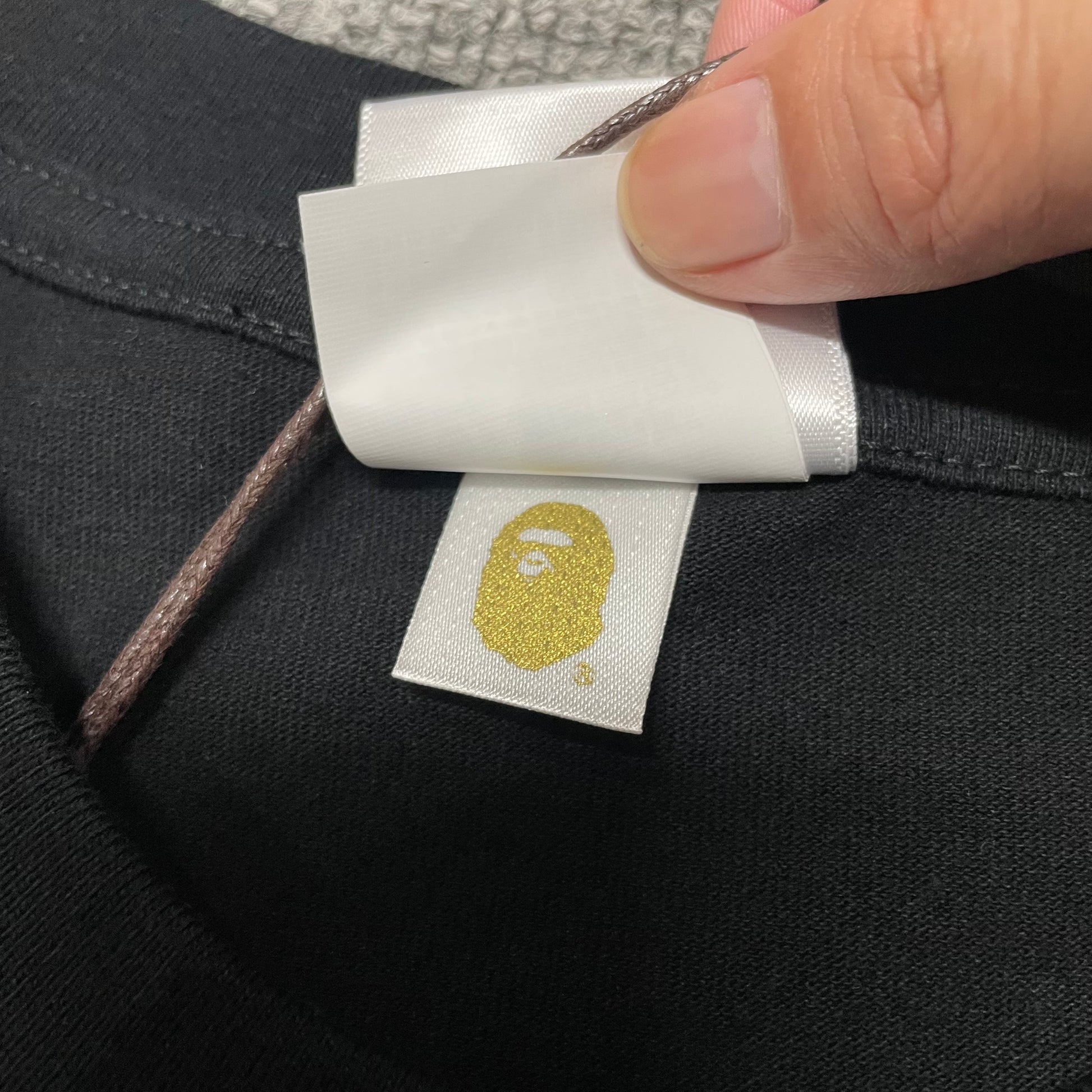 Gold label detail on black BAPE Space Camo Big Ape Head T-shirt