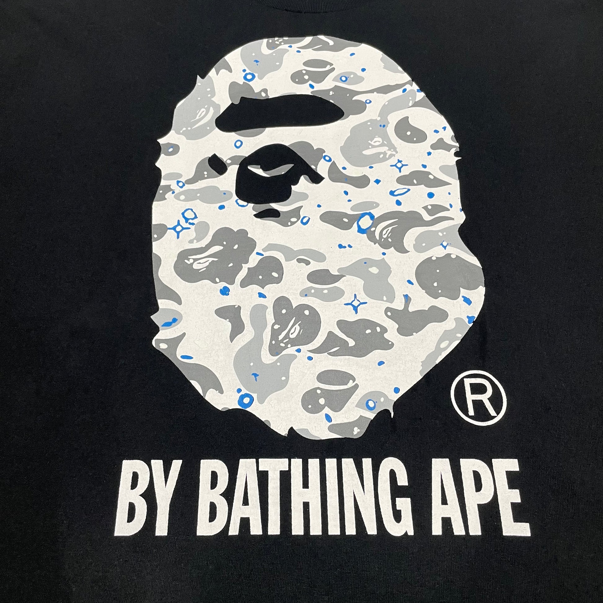 Close-up of grey white and blue Space Camo Ape Head graphic on black BAPE T-shirt