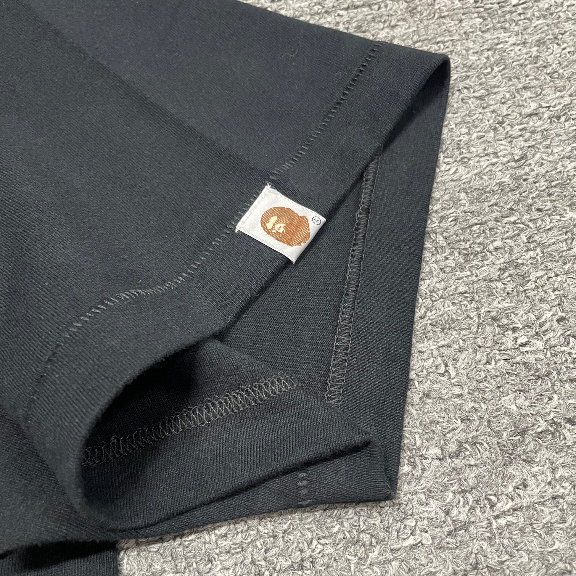 Sleeve label detail of black BAPE Baby Milo Ape Head T-shirt