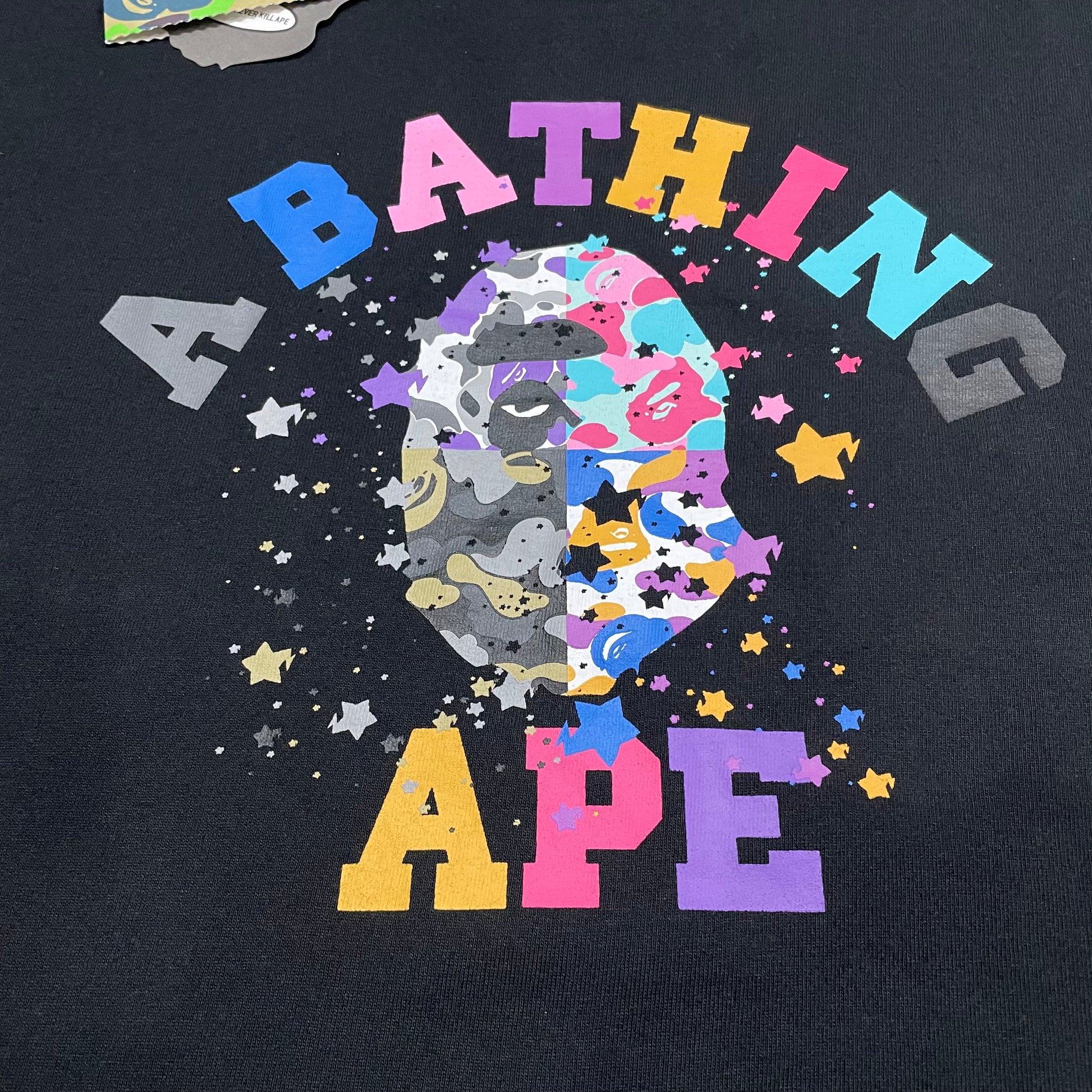 Close-up of multicolor STA stars and Ape Head print on black BAPE T-shirt