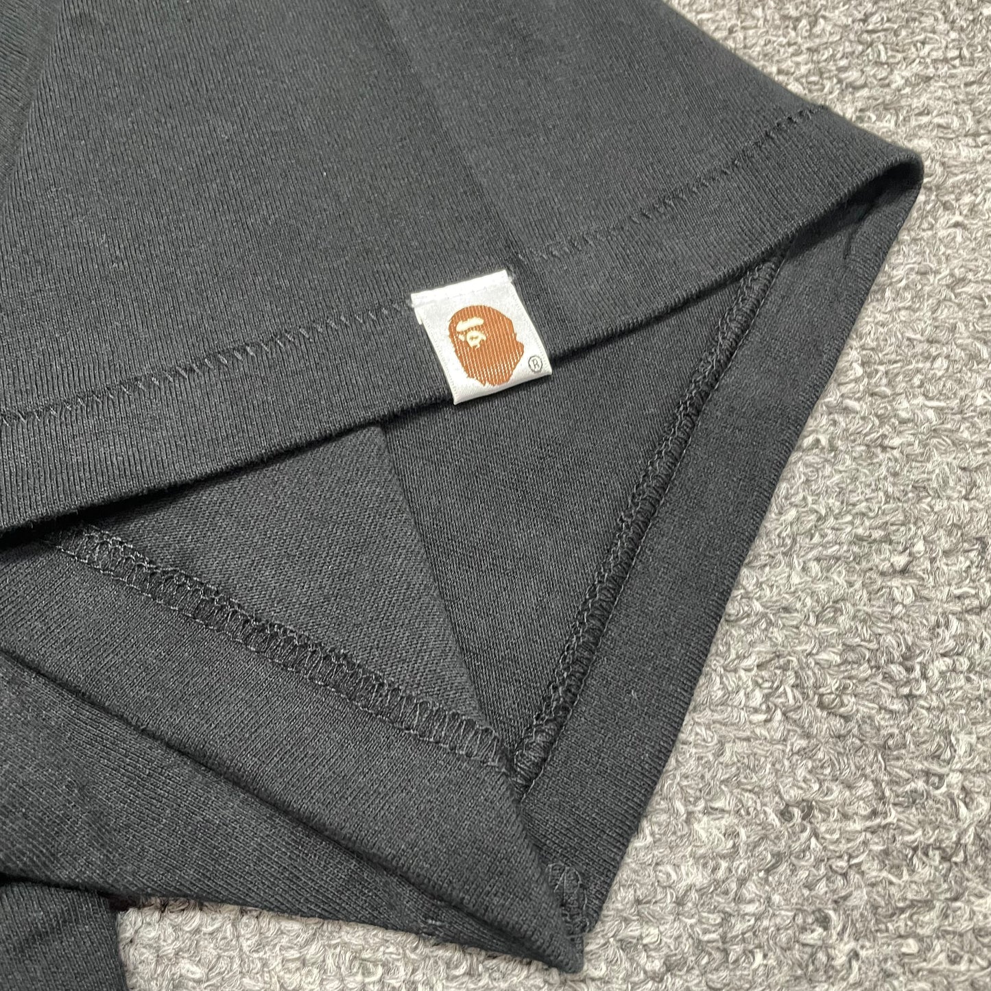 BAPE Ape Head sleeve label detail on black STA College T-shirt