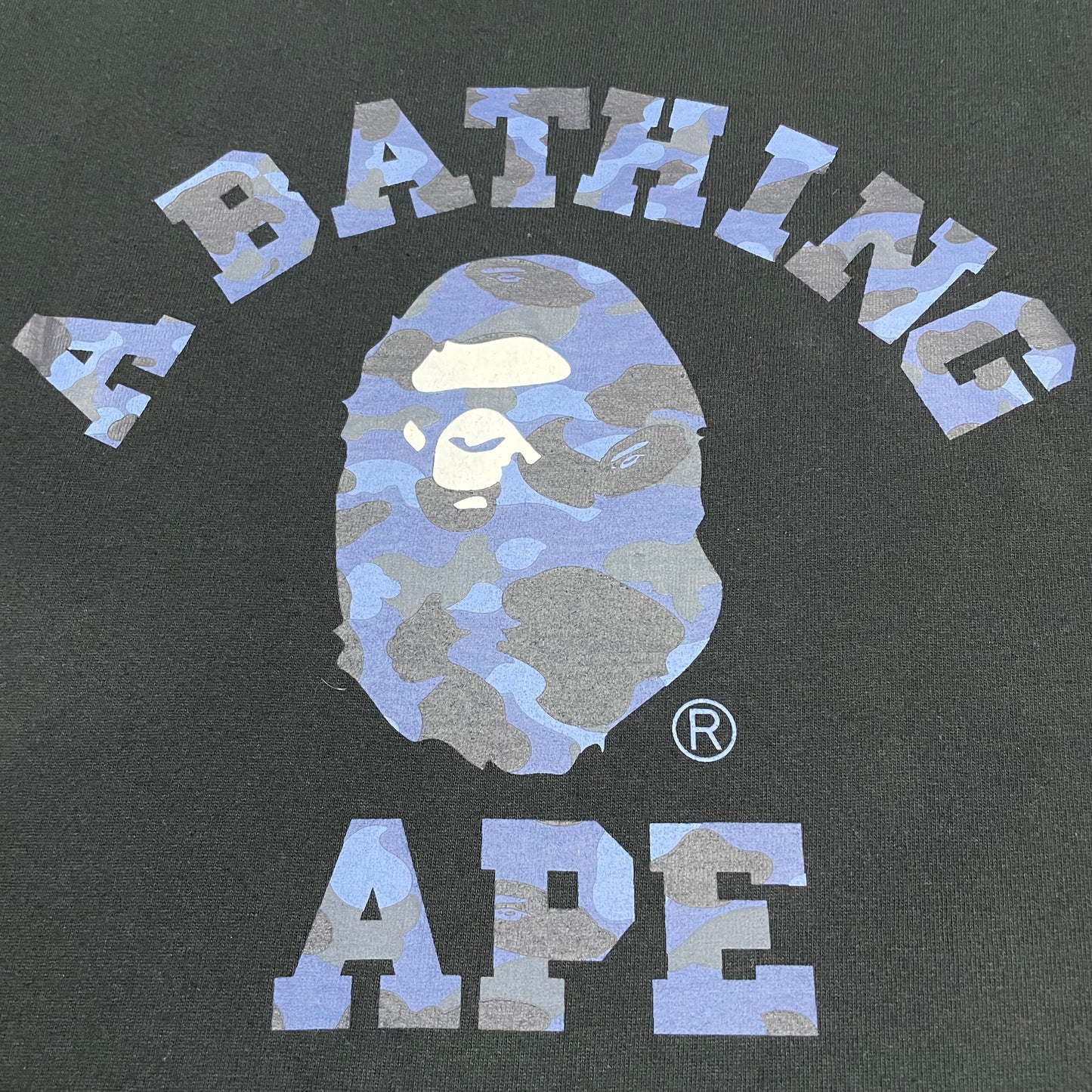 Detailed view of blue camo Ape Head graphic on black BAPE T-shirt