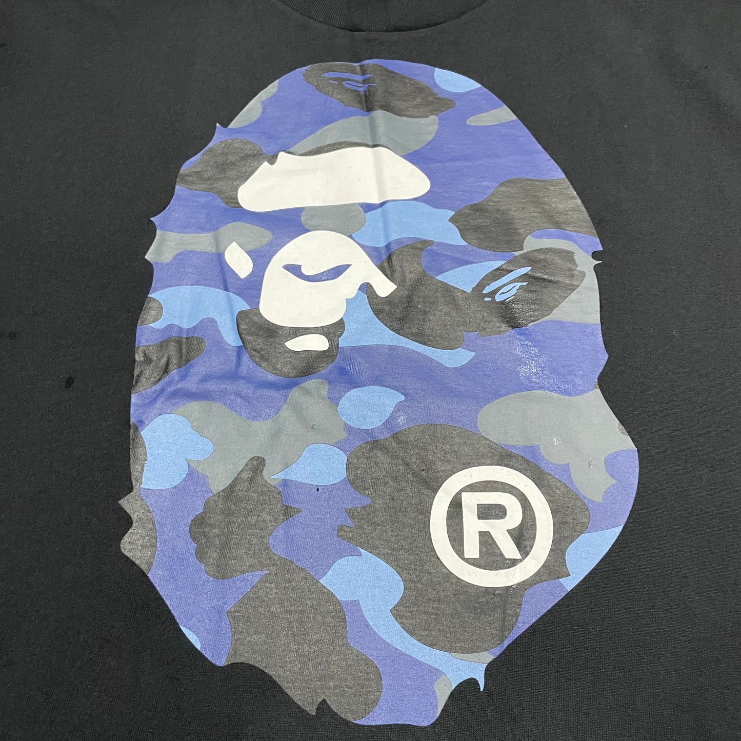 Close-up of blue ABC Camo Big Ape Head print on black BAPE T-shirt
