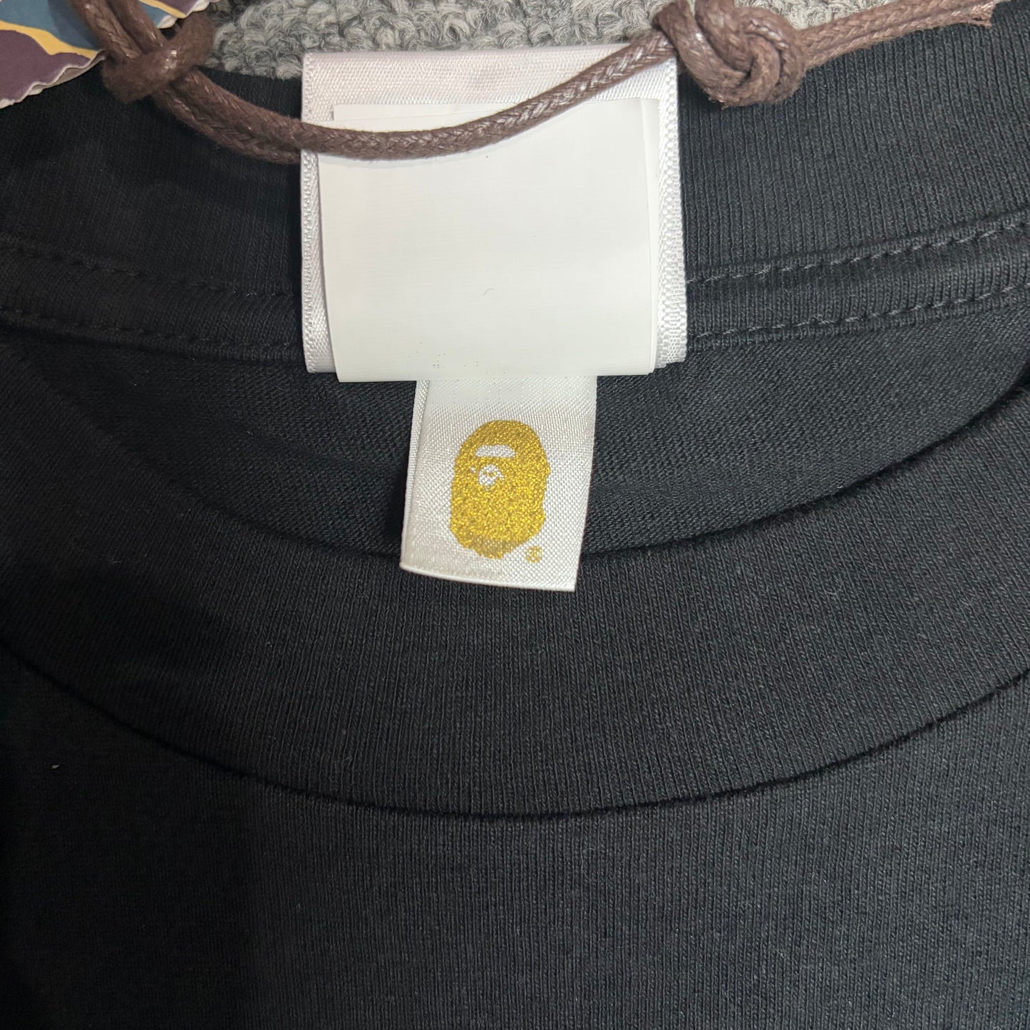Gold label detail on black BAPE x Chrome Hearts T-shirt