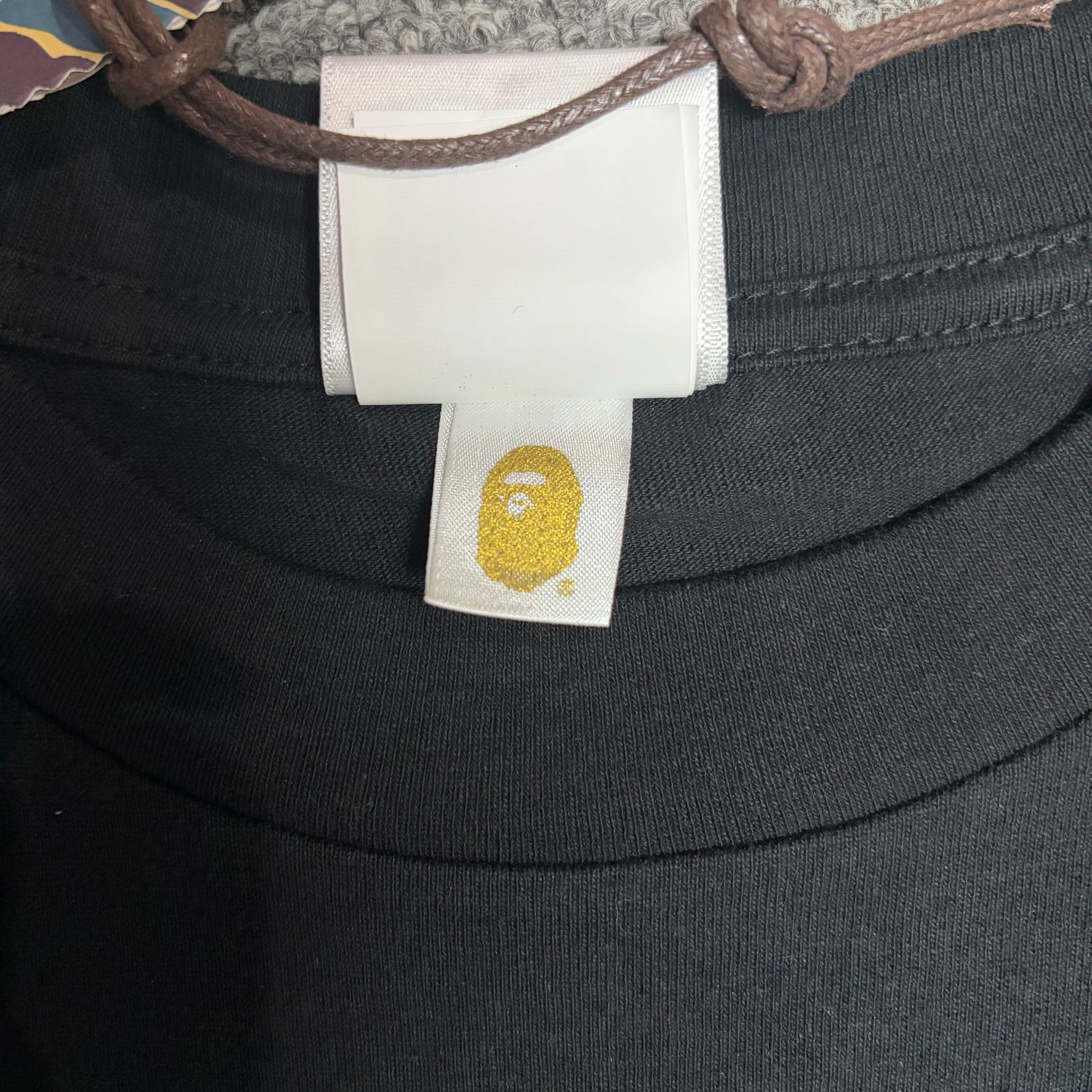 Gold label detail on black BAPE x Chrome Hearts T-shirt