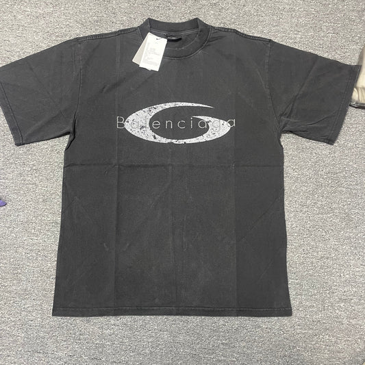 Black crew‑neck short‑sleeve tee flat‑lay shot, large silver‑grey distressed crescent‑shaped chest graphic print, paper hangtag attached at collar