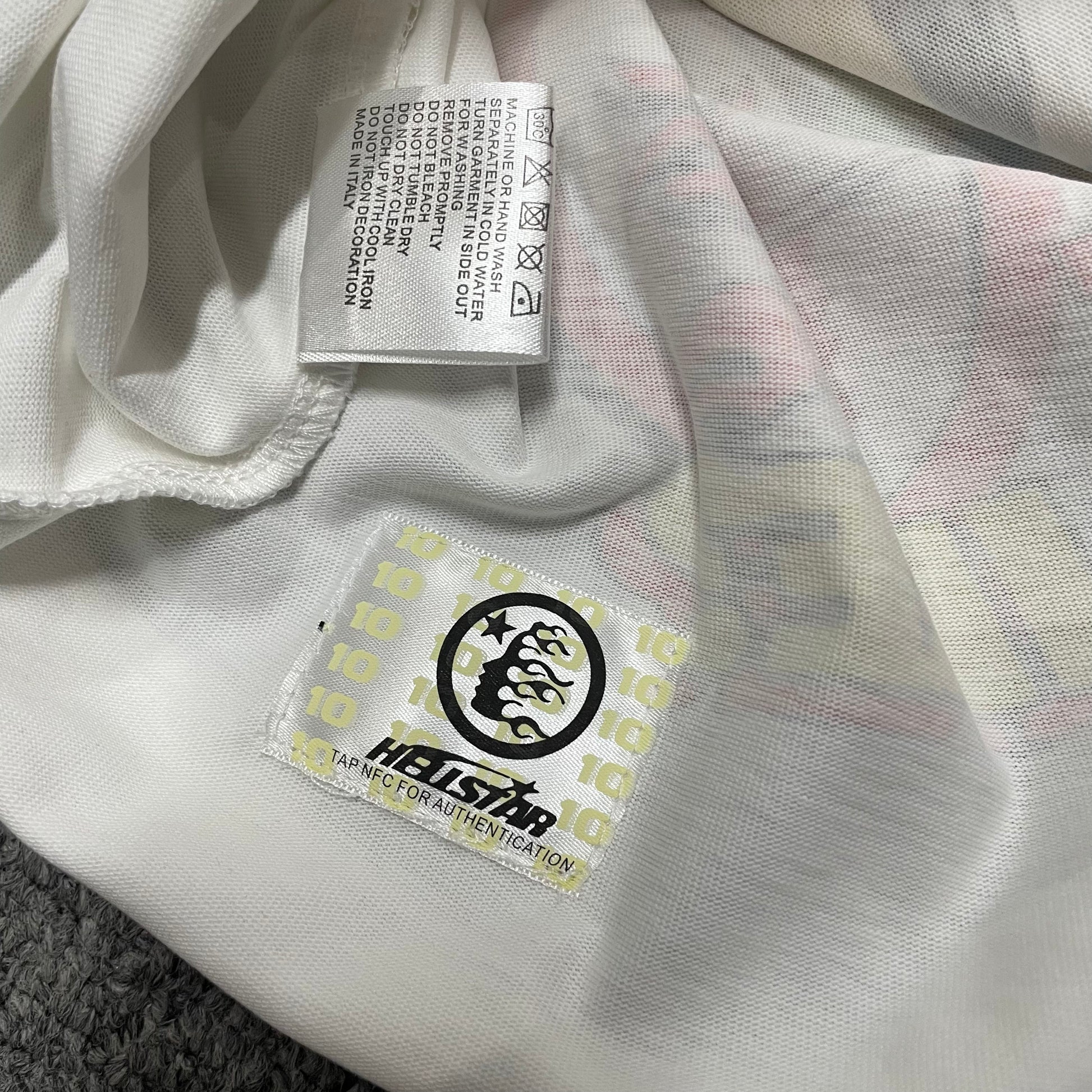 Hellstar Records T-shirt NFC tag detail shown for wholesale product inspection
Hellstar T-shirt wash label showing fabric composition, size and garment care information