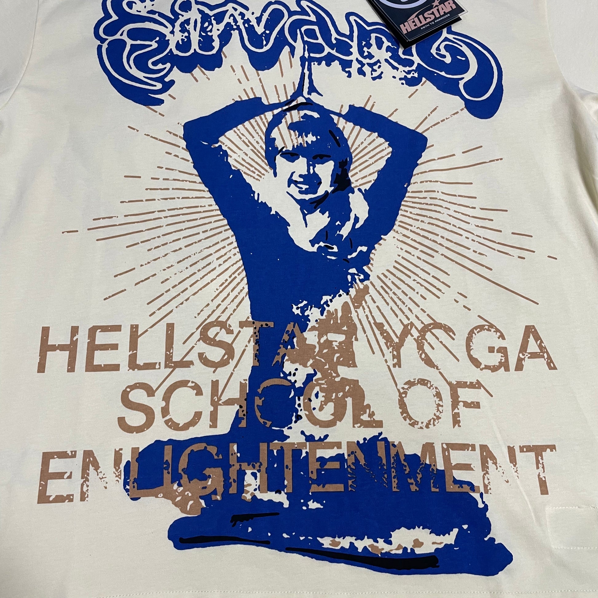 Full front graphic of the Hellstar Yoga School of Enlightenment T-Shirt with blue meditation figure artwork
Full back graphic of the Hellstar Yoga T-Shirt featuring a large blue Om symbol and Reach Your Inner Peace artwork
Close-up of the blue and tan yoga figure print on the Hellstar School of Enlightenment T-Shirt
Detailed view of the distressed lettering and layered blue and tan print on the Hellstar Yoga graphic T-shirt