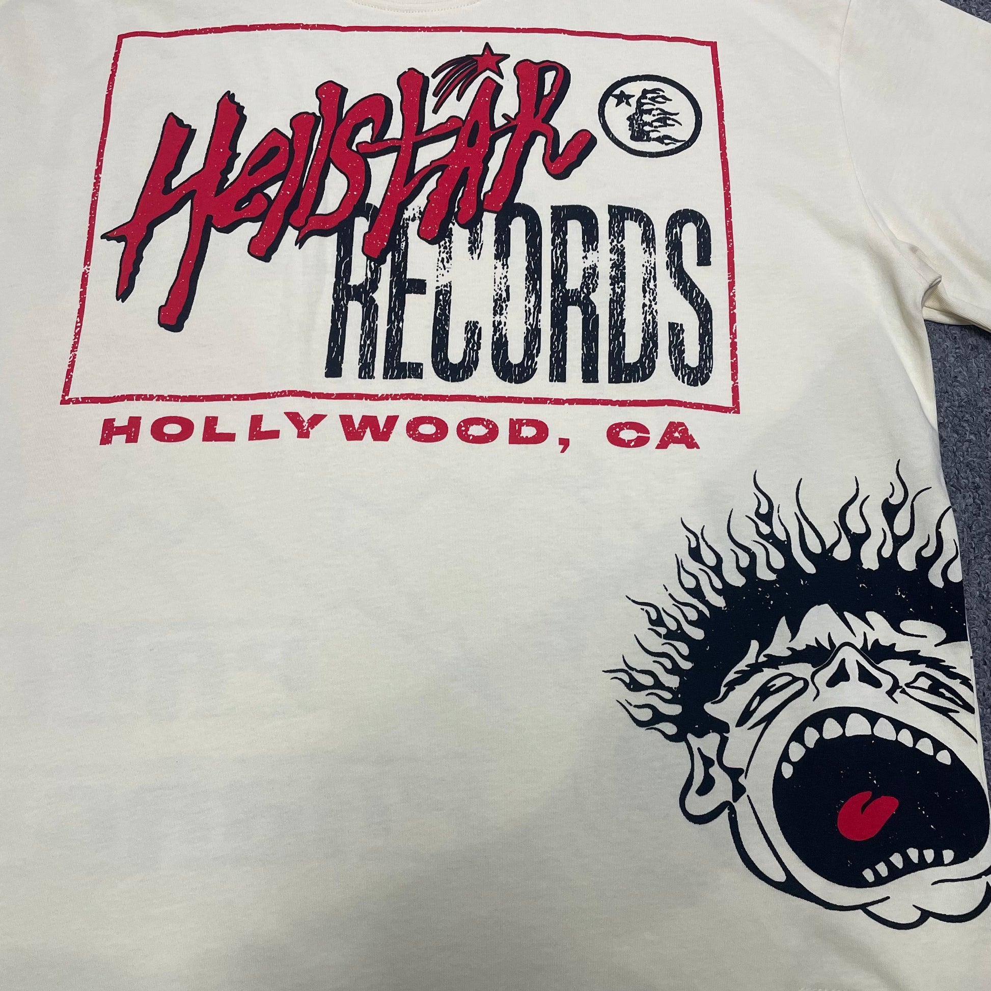 Full Hellstar Records Hollywood graphic print on the Path to Paradise T-Shirt
Close-up of the distressed Hellstar Records and Hollywood lettering print
Detailed view of the distressed red black and white print texture on the Hellstar T-Shirt
Oversized screaming-face side graphic with flame details on the Hellstar Path to Paradise T-Shirt
Close-up of the flame and open-mouth side artwork on the Hellstar graphic T-shirt
Full back graphic artwork on the Hellstar Path to Paradise Records T-Shirt