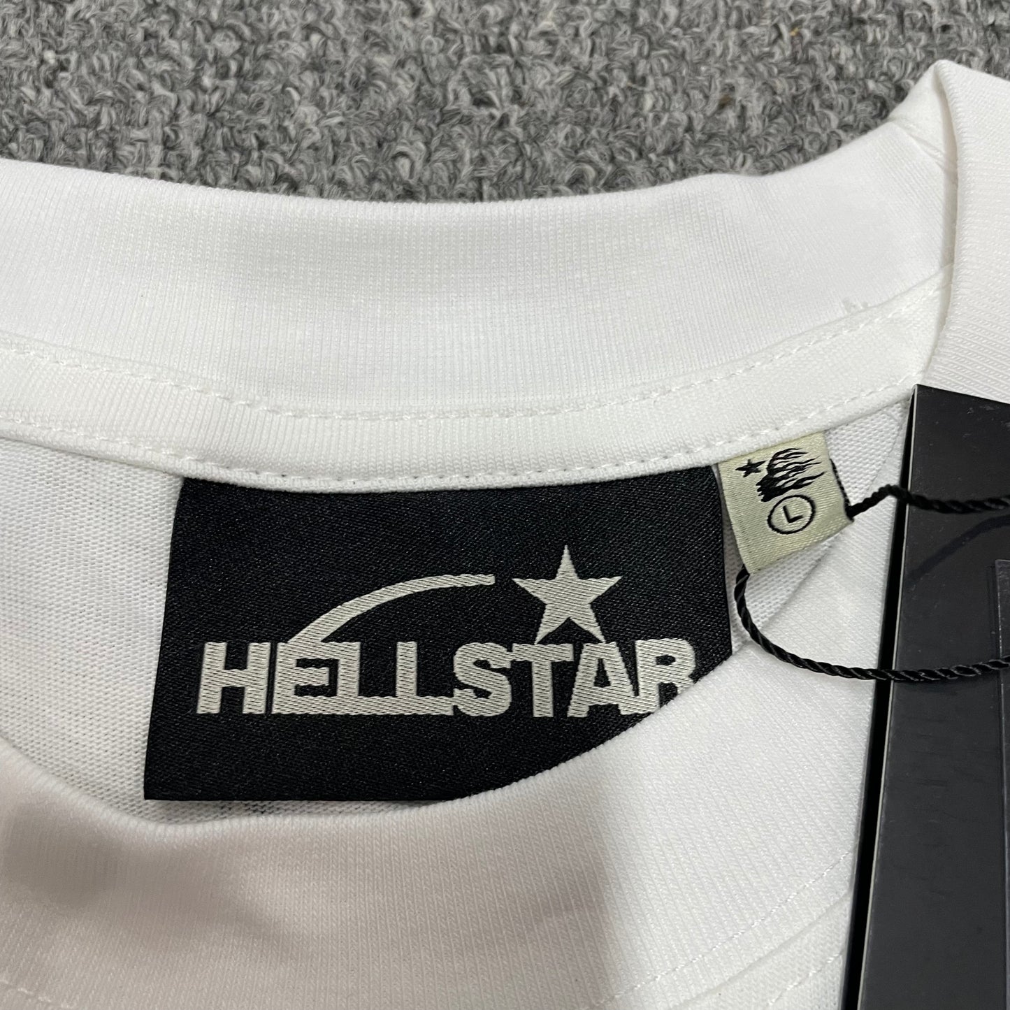 Hellstar branded neck label and crew-neck stitching on the Breaking News T-Shirt
Hellstar Breaking News T-Shirt wash label showing fabric size and garment care information
Size label detail inside the Hellstar Breaking News graphic T-shirt
Hellstar branded hangtag attached to the white Breaking News graphic T-shirt