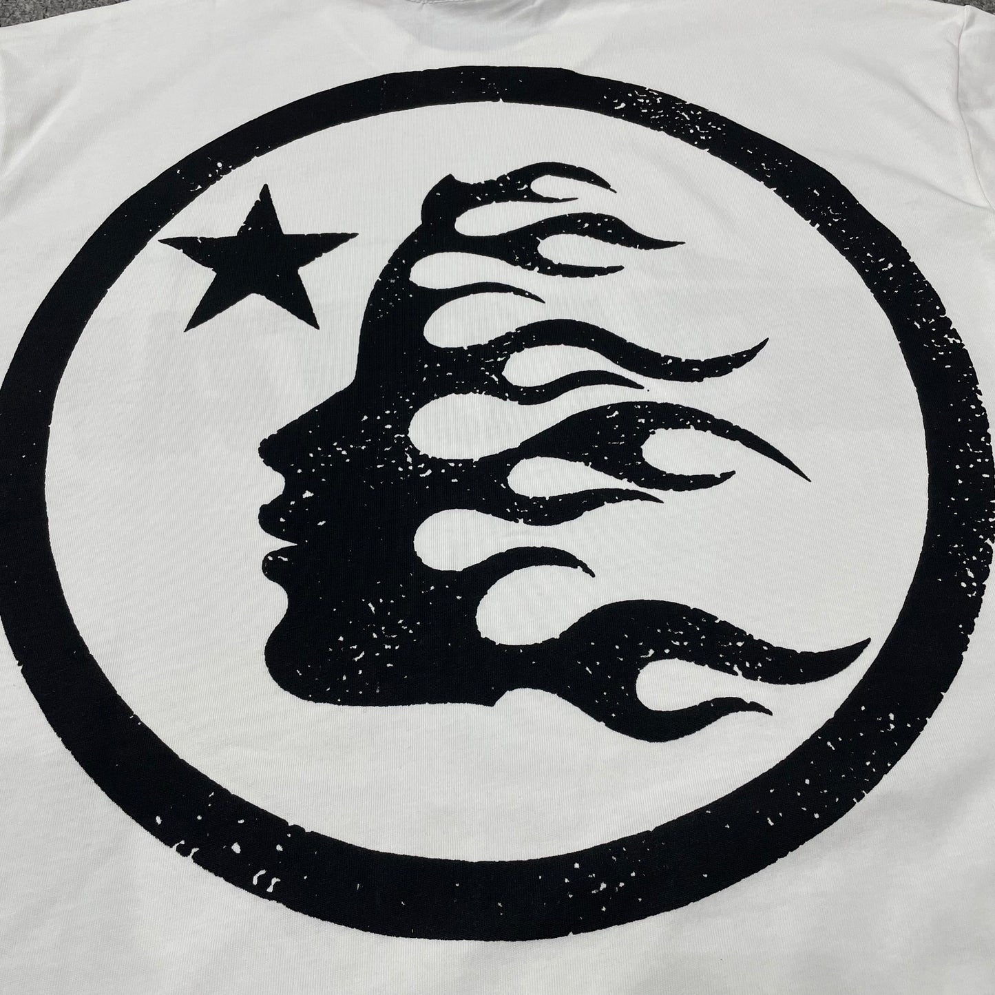Full oversized Hellstar Sports wordmark graphic printed across the front of the white T-shirt
Close-up of the black Hellstar wordmark and shooting-star graphic on the white Sports Logo T-Shirt
Detailed view of the black graphic print texture on the Hellstar Sports Logo white T-shirt
Close-up of the shooting-star graphic above the Hellstar logo on the white T-shirt