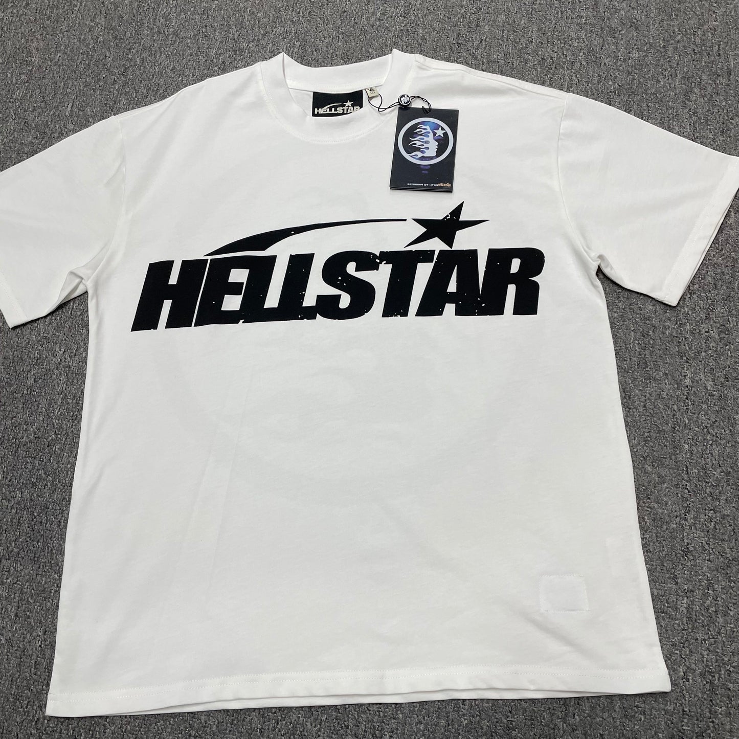 Hellstar Sports Logo T-Shirt in white front view with oversized black wordmark and shooting-star graphic
