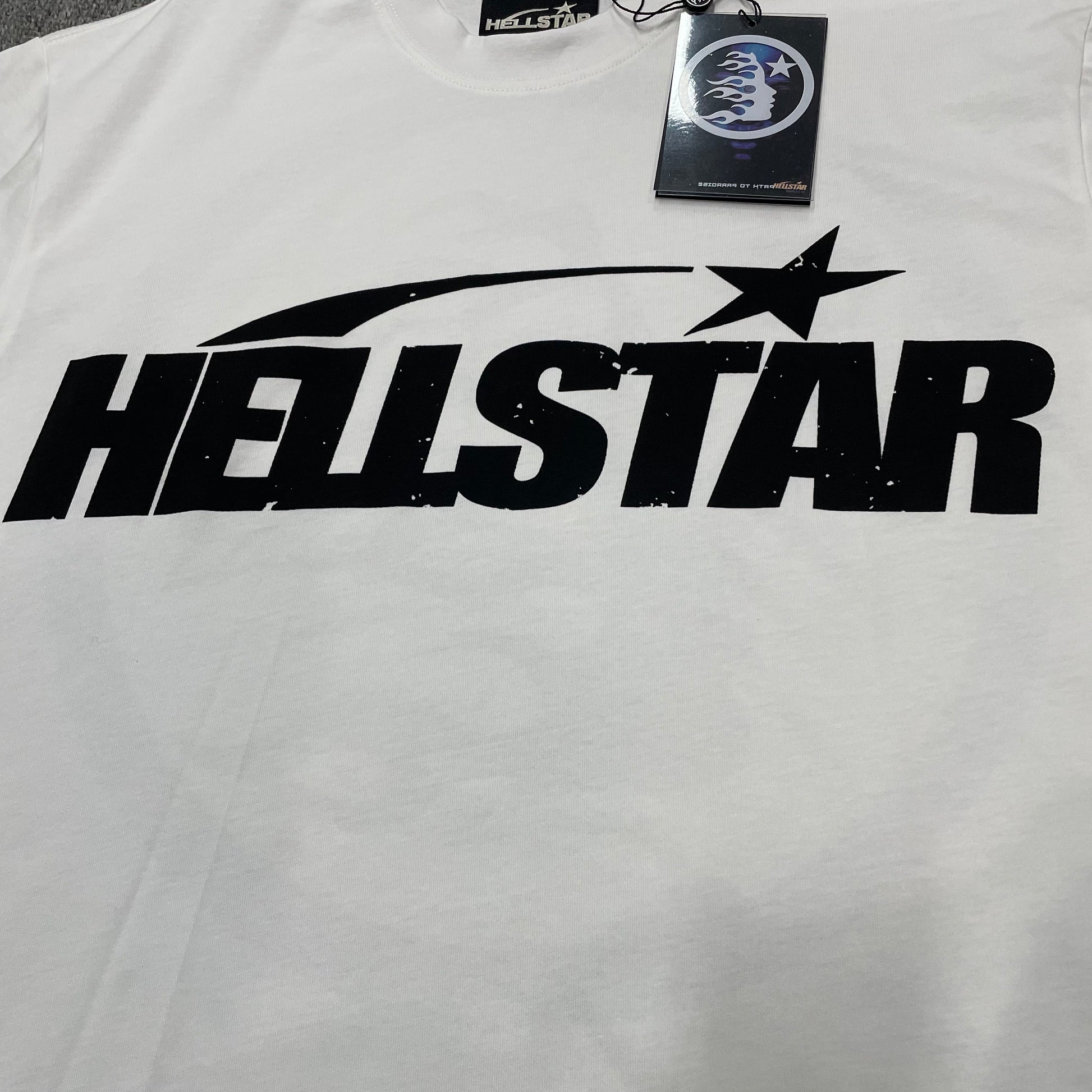 Full oversized Hellstar Sports wordmark graphic printed across the front of the white T-shirt
Close-up of the black Hellstar wordmark and shooting-star graphic on the white Sports Logo T-Shirt
Detailed view of the black graphic print texture on the Hellstar Sports Logo white T-shirt
Close-up of the shooting-star graphic above the Hellstar logo on the white T-shirt