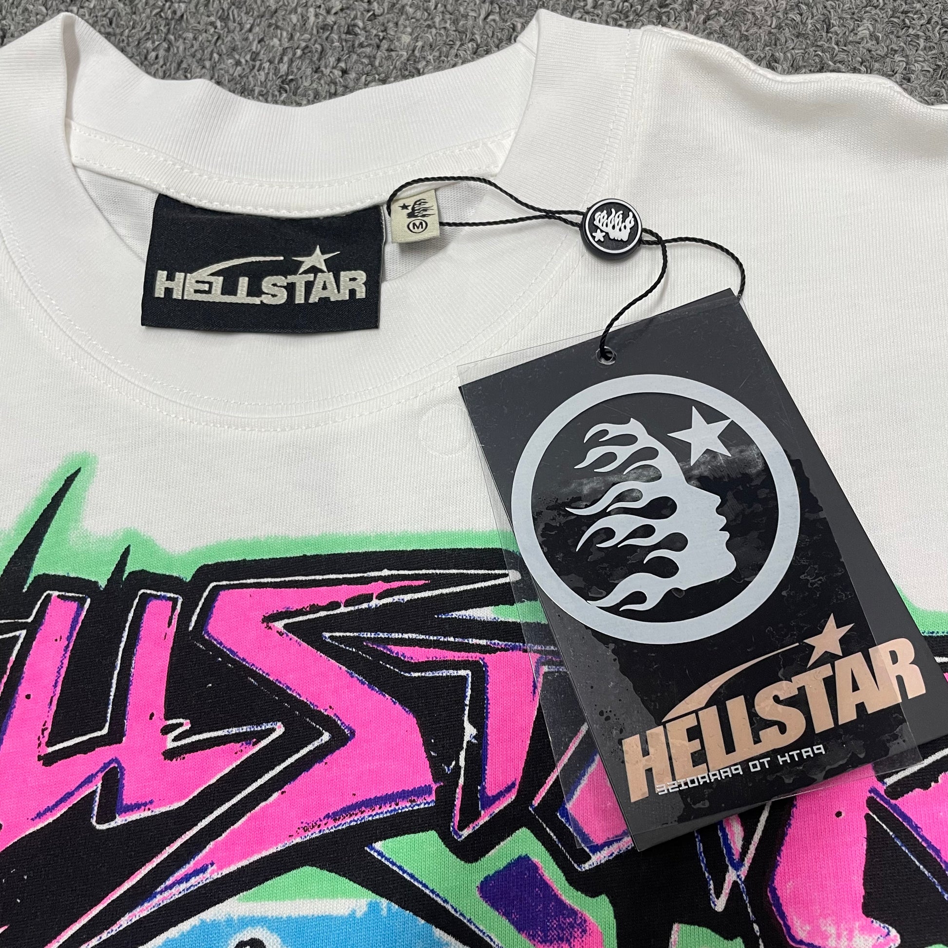 Hellstar branded neck label and crew-neck stitching on the white Online T-Shirt
Size label detail inside the white Hellstar Online graphic T-shirt
Hellstar branded hangtag attached to the white Online graphic T-shirt