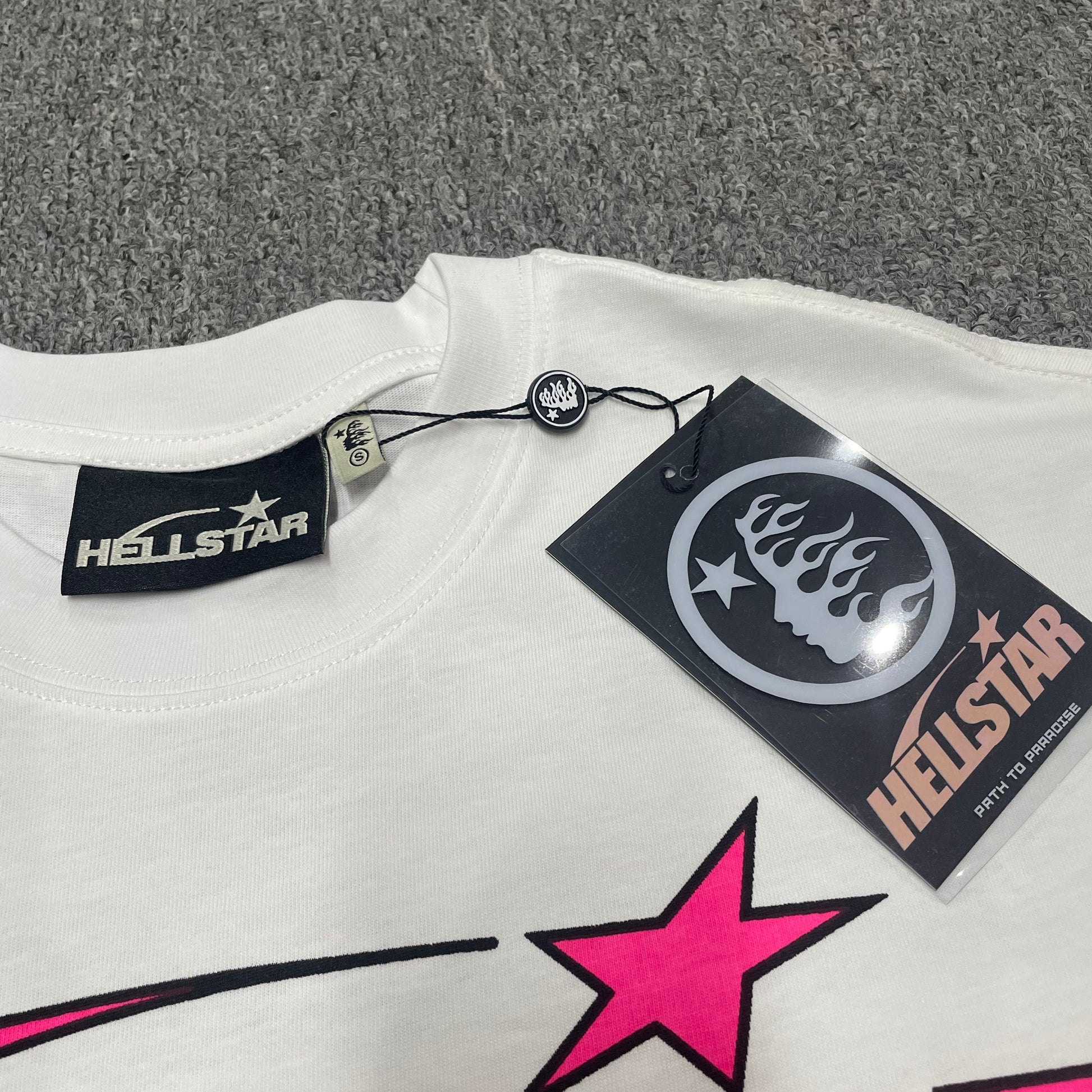 Hellstar branded neck label and crew-neck stitching on the Pixel T-Shirt
White ribbed crew-neck and stitching detail on the Hellstar Pixel T-Shirt
Size label detail inside the white Hellstar Pixel graphic T-shirt
Hellstar branded hangtag attached to the white Pixel graphic T-shirt