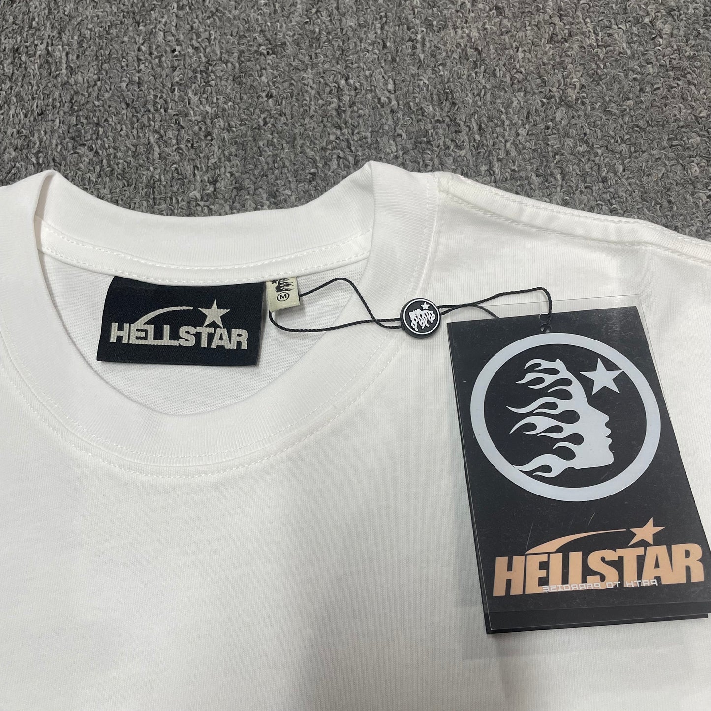 Hellstar branded neck label and crew-neck stitching on the Path to Paradise T-Shirt
White ribbed crew-neck and stitching detail on the Hellstar graphic T-shirt
Size label detail inside the white Hellstar Path to Paradise graphic T-shirt
Hellstar branded hangtag attached to the white Path to Paradise Logo T-Shirt