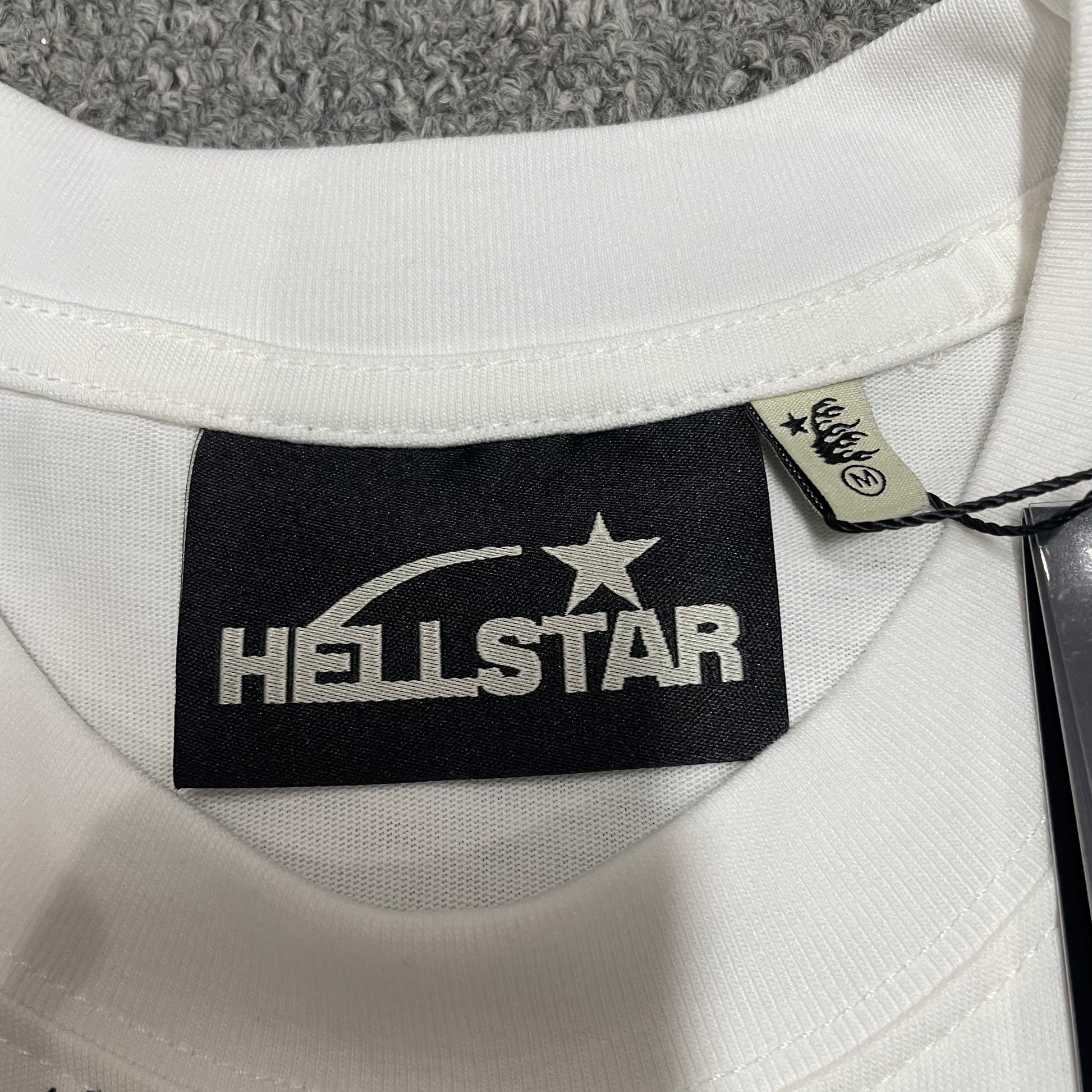 Hellstar branded neck label and crew-neck stitching on the Flame Tribal Motion T-Shirt
Ribbed crew-neck collar and stitching detail on the Hellstar graphic T-shirt
Size label detail inside the Hellstar Flame Tribal Motion graphic T-shirt