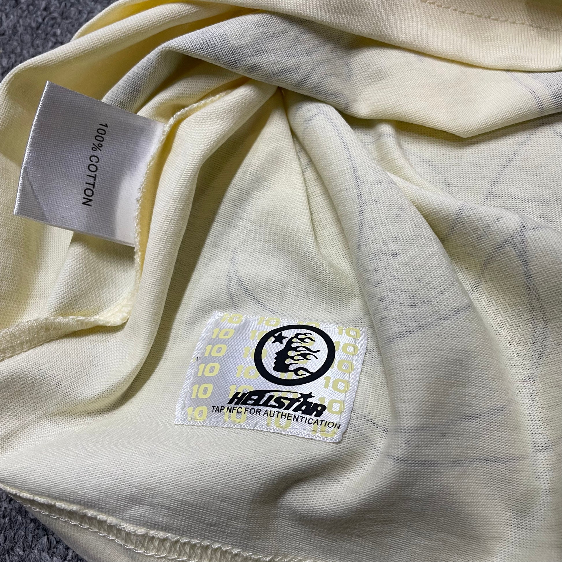 NFC tag detail on the Hellstar Human Development T-Shirt for product inspection
Hellstar Human Development T-Shirt wash label showing fabric size and garment care information