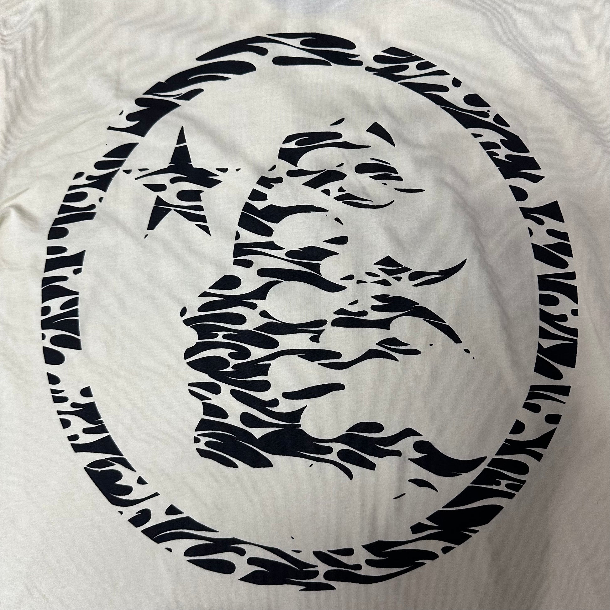 Full oversized flame-face emblem printed on the back of the Hellstar Classic Logo T-Shirt
Large circular Hellstar flame and star emblem on the back of the cream T-shirt
Black flame-profile character graphic on the back of the Hellstar Classic T-Shirt
Close-up of the flame-profile face inside the circular Hellstar back emblem