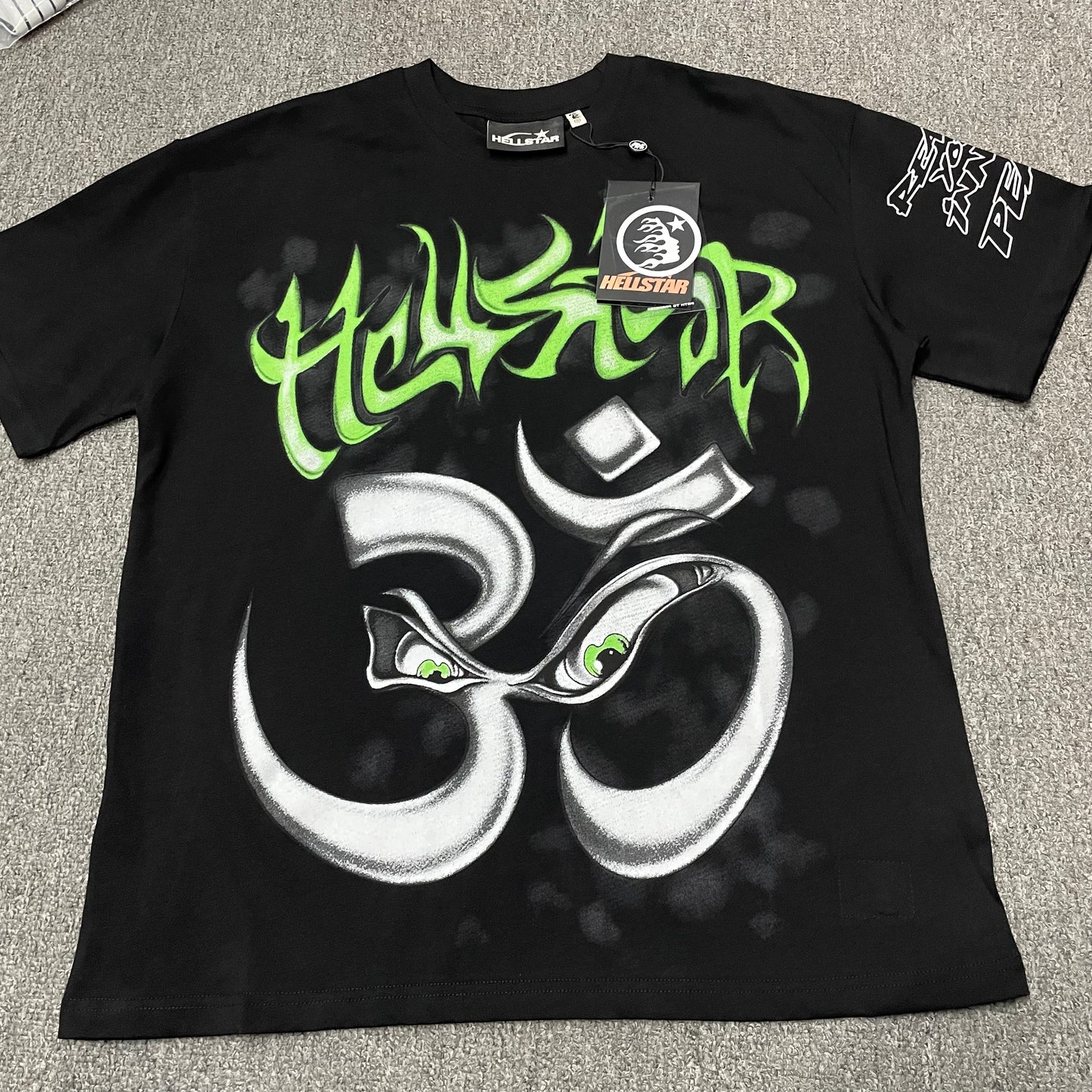 Hellstar Reach Your Inner Peace Om T-Shirt in black front view with green logo and silver yoga graphic