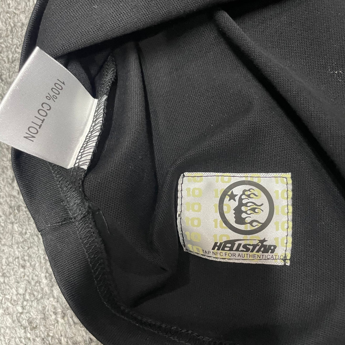 Hellstar Blur T-Shirt wash label showing size fabric and garment care information
NFC tag detail on the Hellstar Blur T-Shirt for product inspection