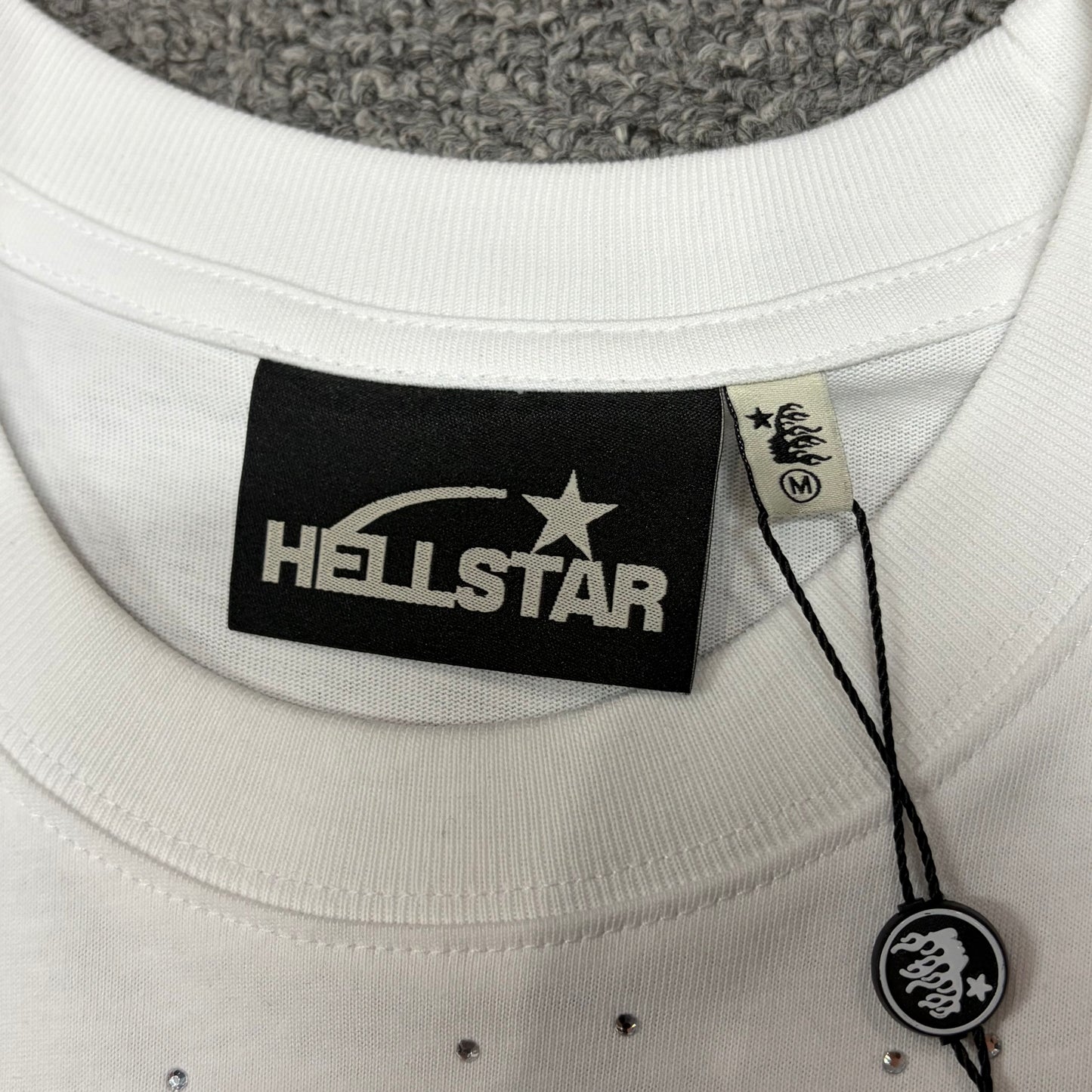 Hellstar branded neck label and crew-neck stitching on the Xray T-Shirt
White ribbed crew-neck collar and stitching detail on the Hellstar Xray T-Shirt
Size label detail inside the white Hellstar Xray Graphic T-Shirt