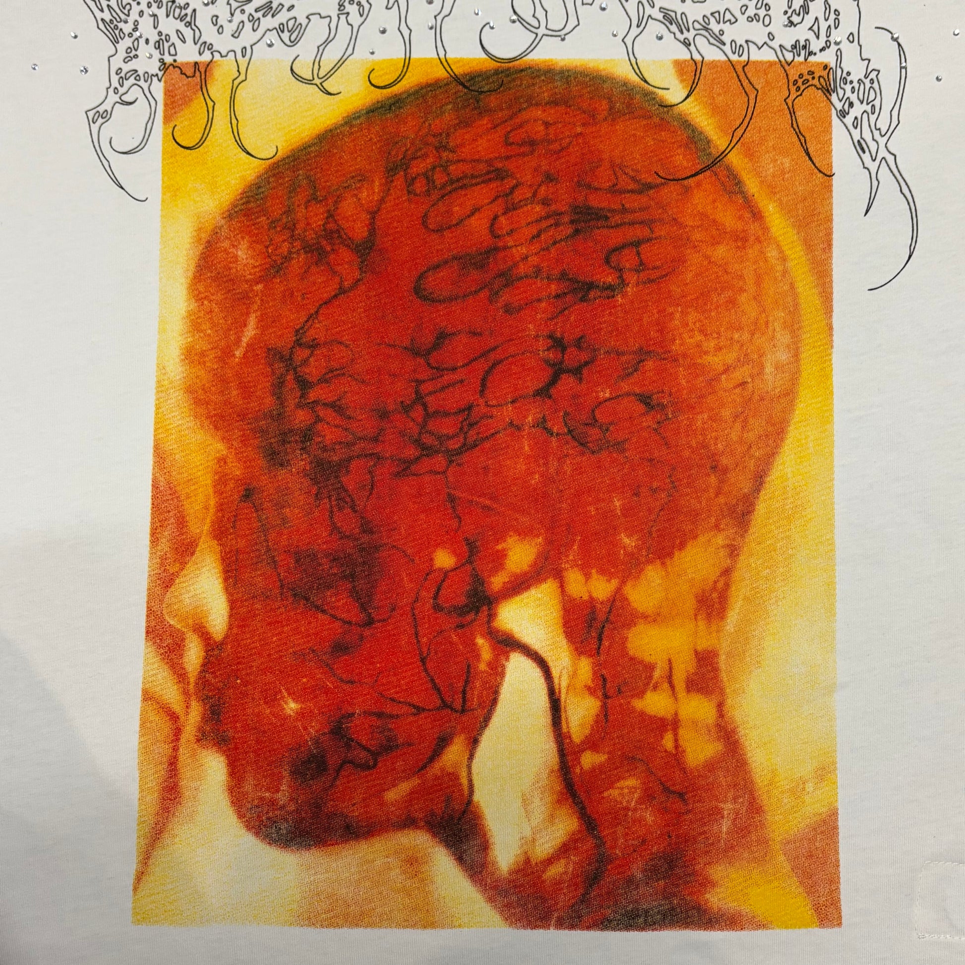 Reflective rhinestone details scattered across the chest of the Hellstar Xray T-Shirt
Full orange X-ray head graphic printed across the front of the white Hellstar T-Shirt
Oversized side-profile X-ray head illustration on the Hellstar Xray T-Shirt
