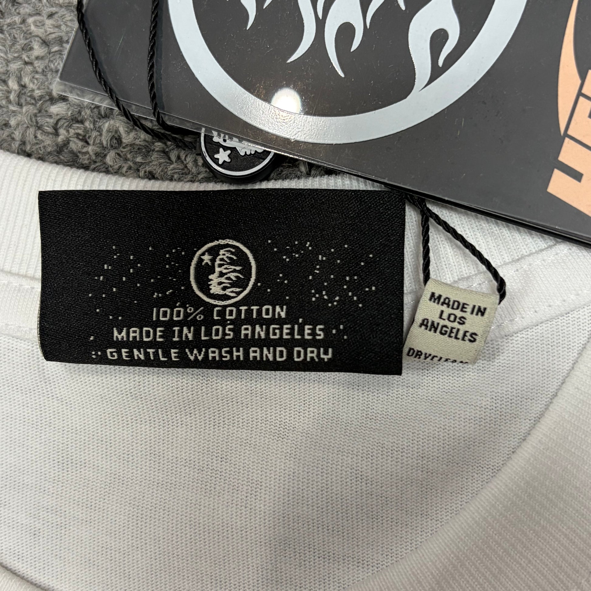 Hellstar branded hangtag attached to the white Xray graphic T-shirt
Front view of the Hellstar flame and star logo hangtag